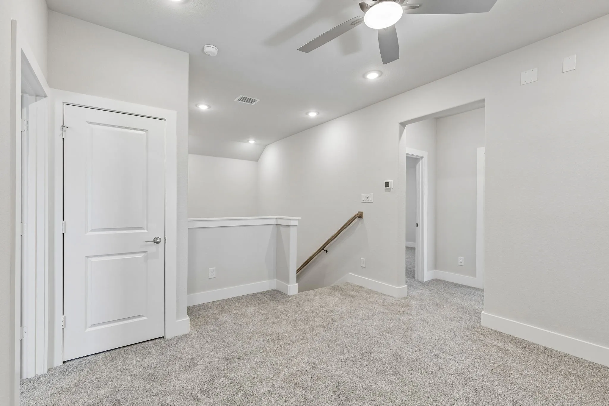 Carpeted room with recessed lighting, ceiling fan, and white paneled doors
