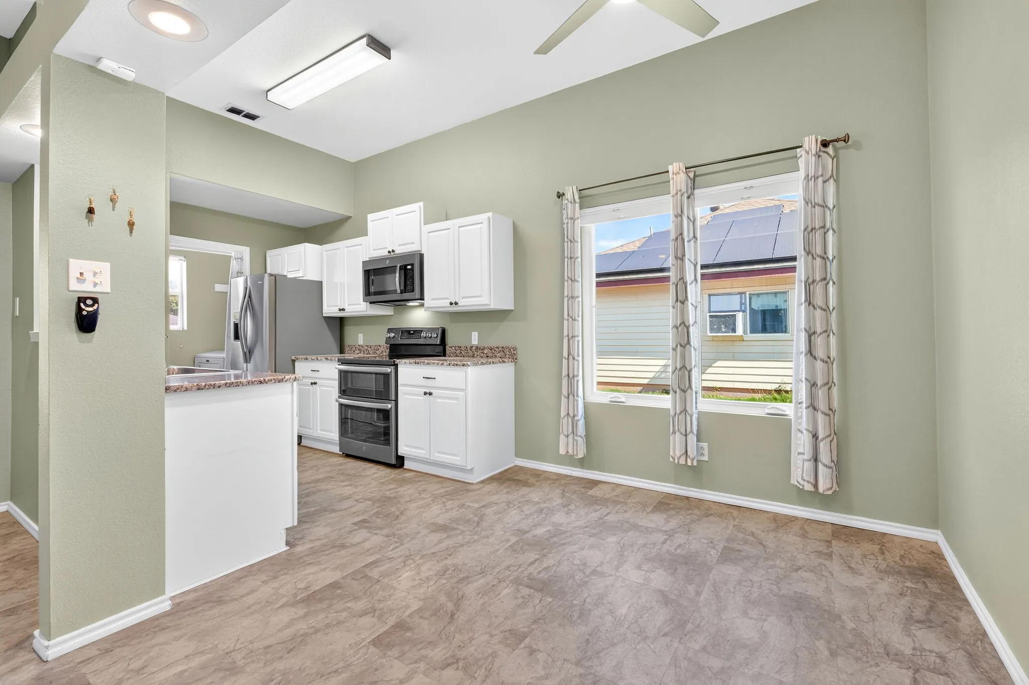 Dining area off kitchen with white cabinetry, stainless steel appliances, and a double oven range.