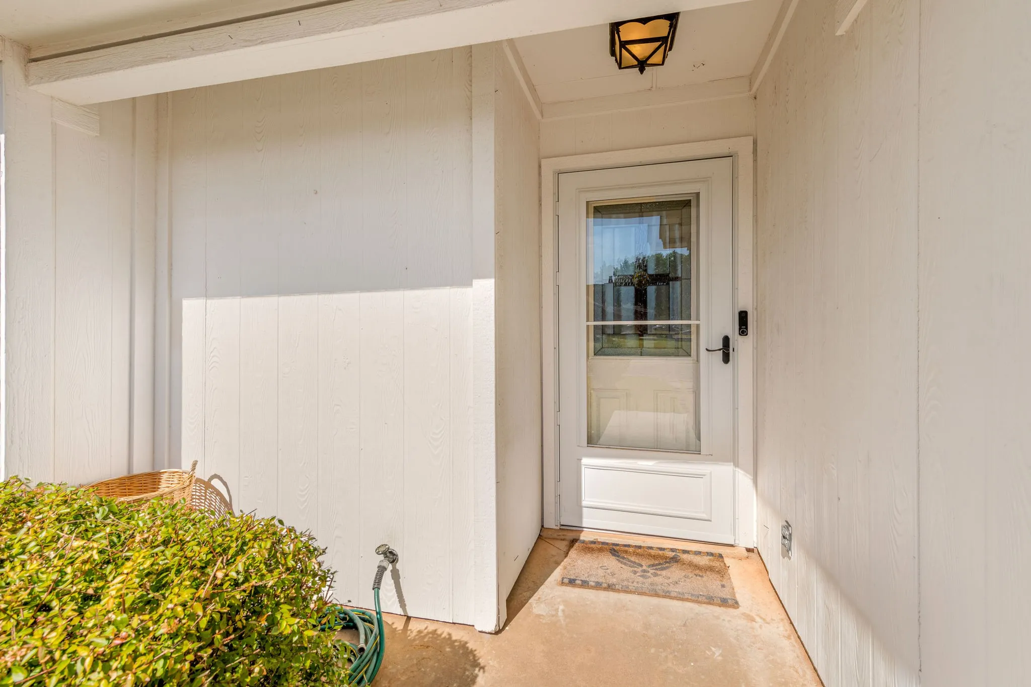 Full-light storm door, covered entry and decorative front door.