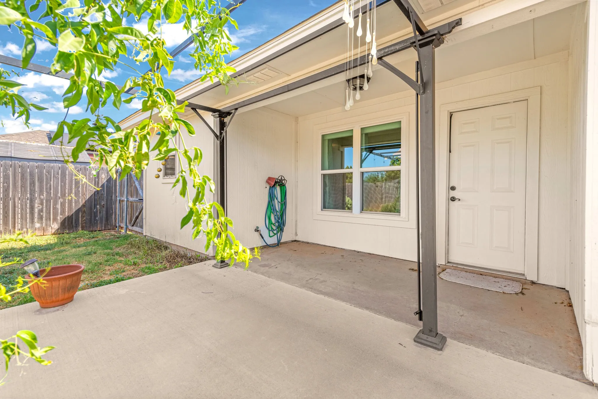 Back covered patio with metal pergola.