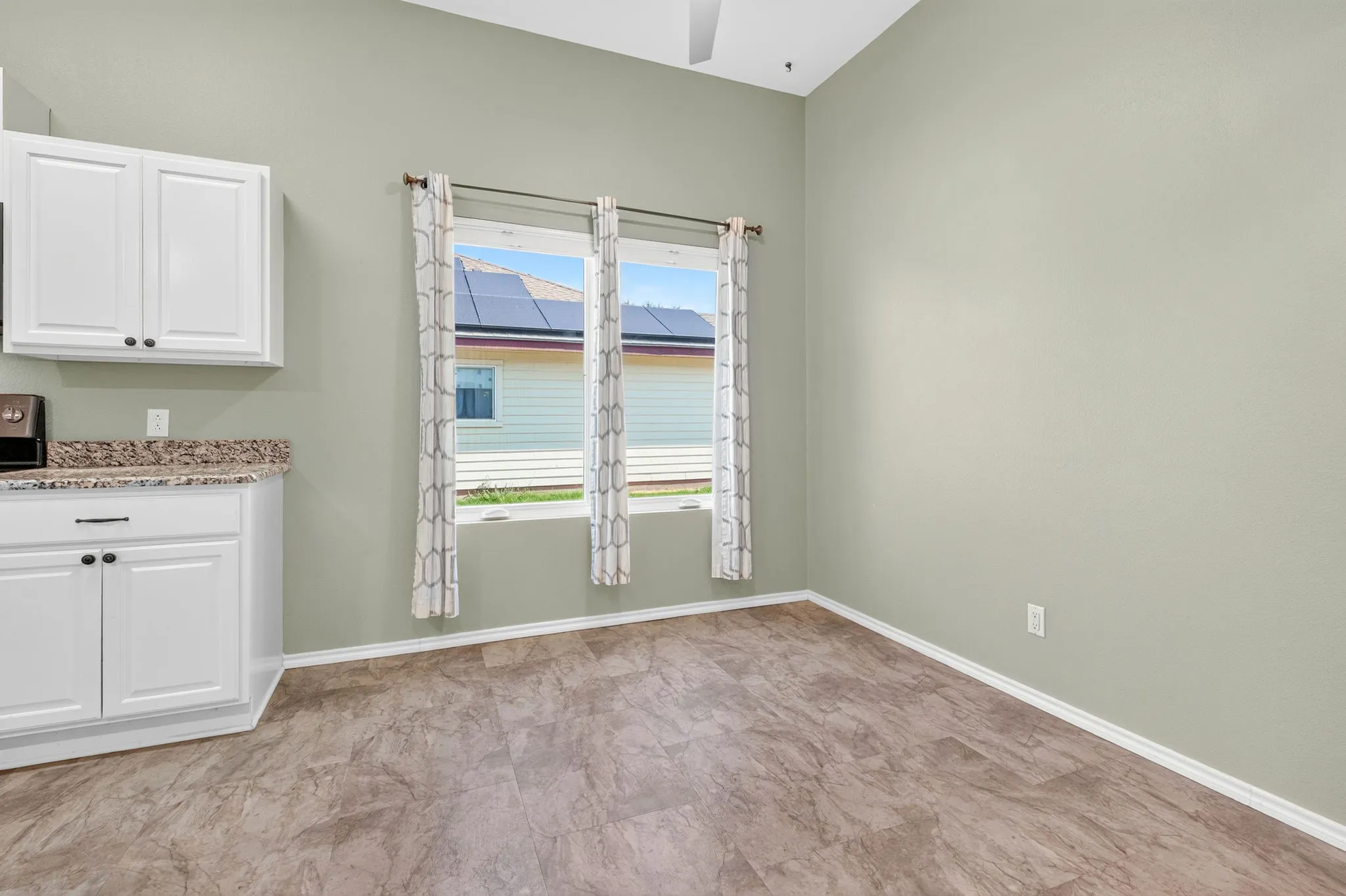 Dining area with double windows and ceiling fan.