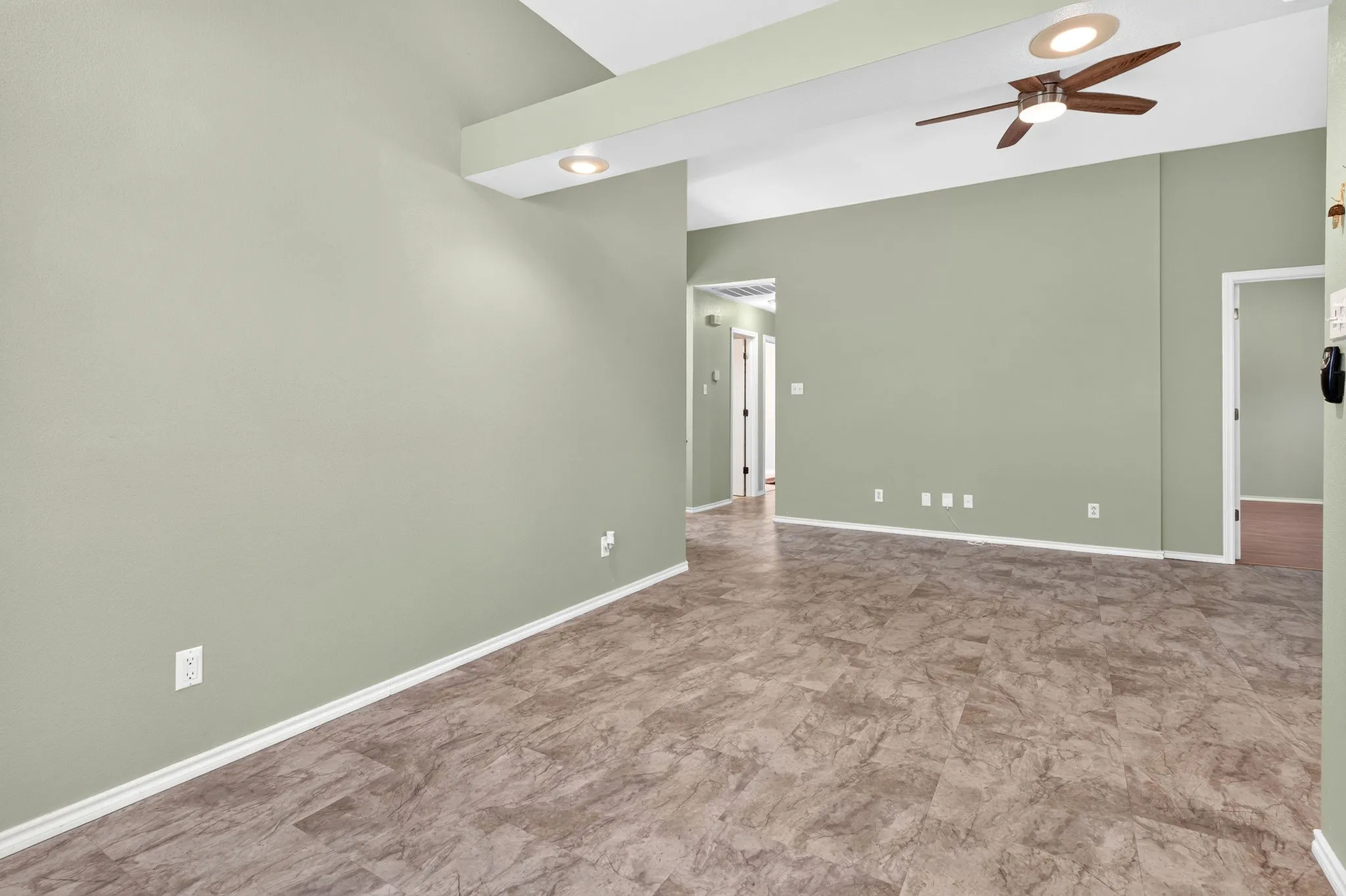 View into living room from dining with recessed lighting.