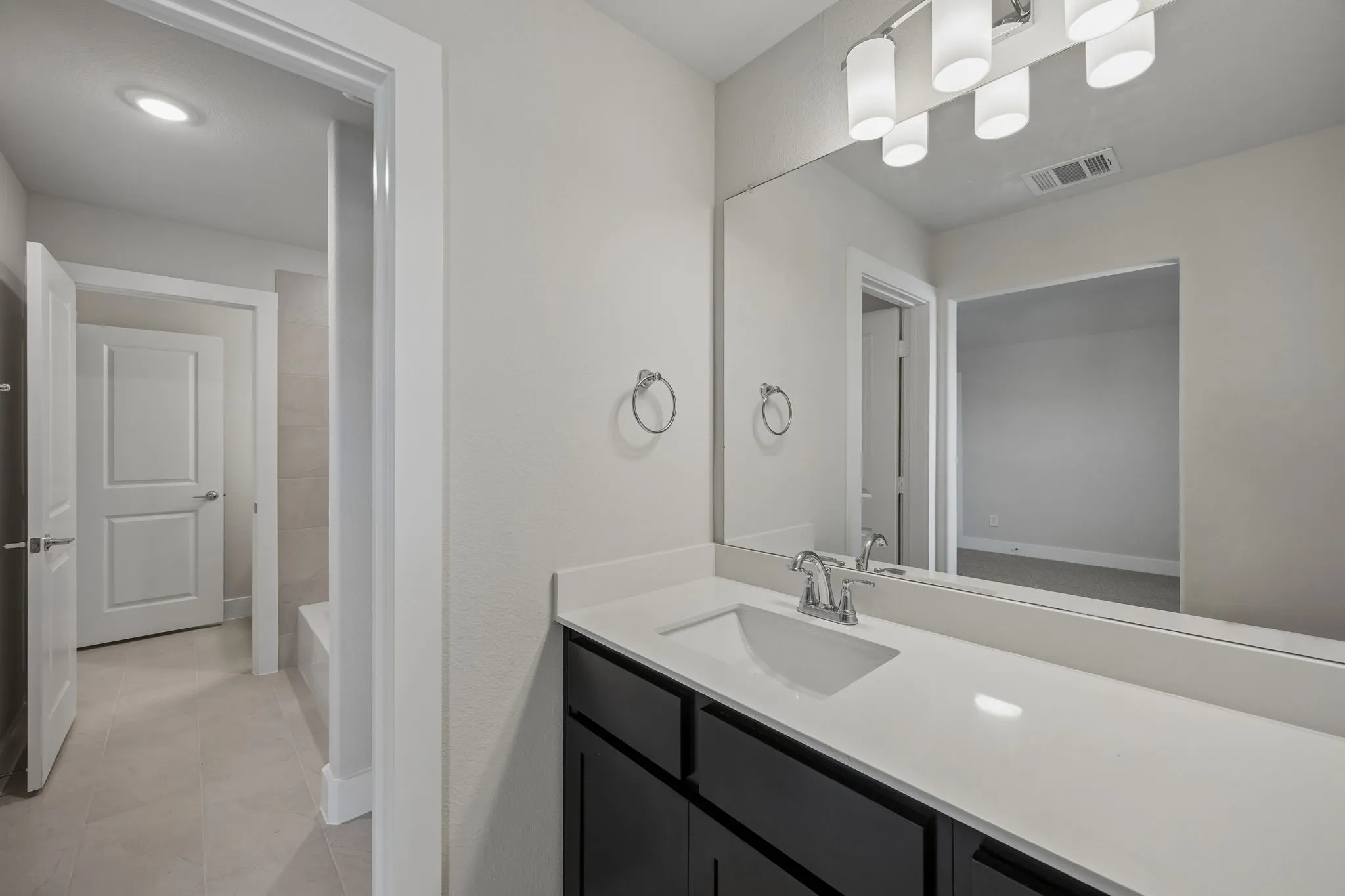 Vanity with a single undermount sink, a chrome faucet, and a quartz countertop