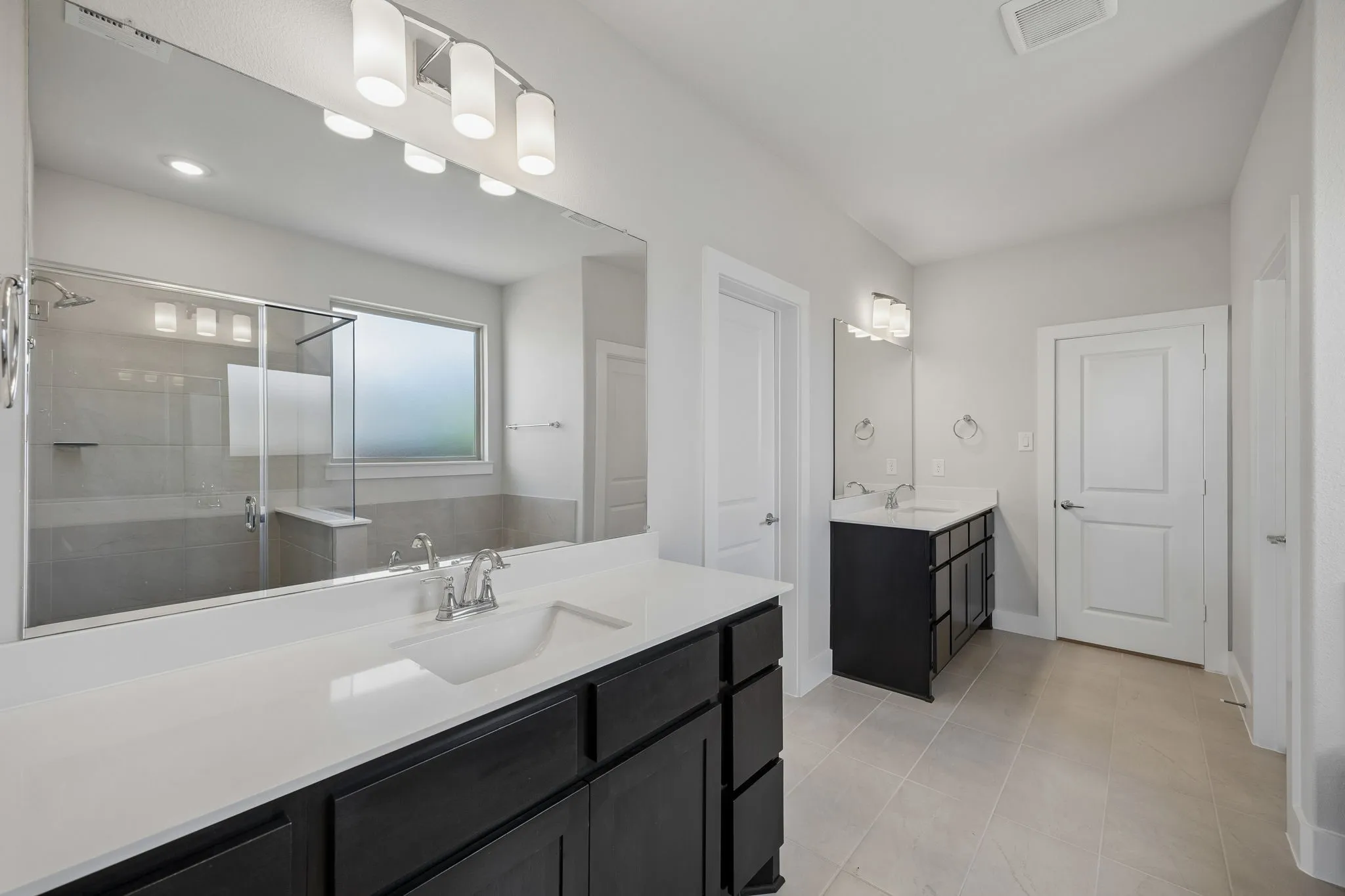 Dual dark wood-finish vanities with light countertops