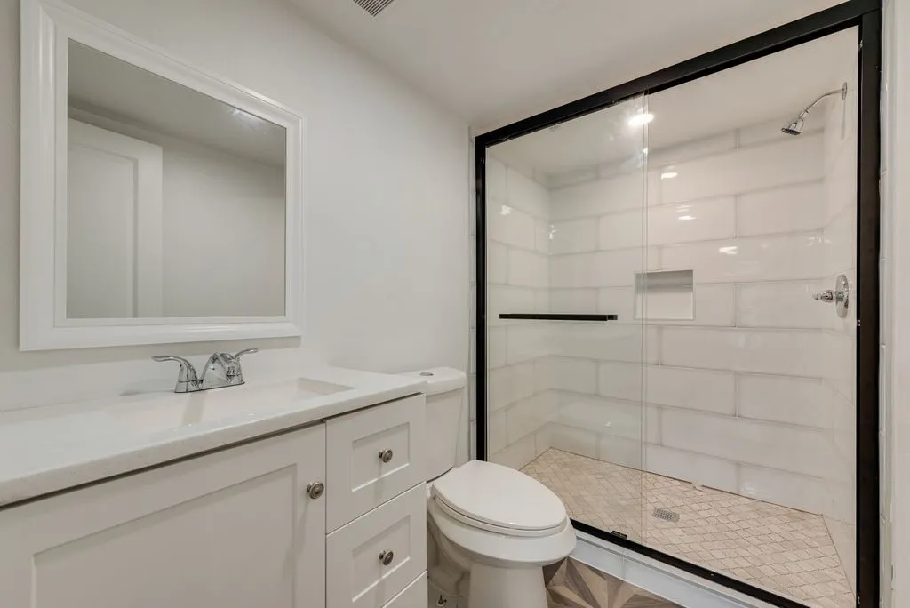 White shaker vanity with integrated sink, chrome faucet, and framed mirror