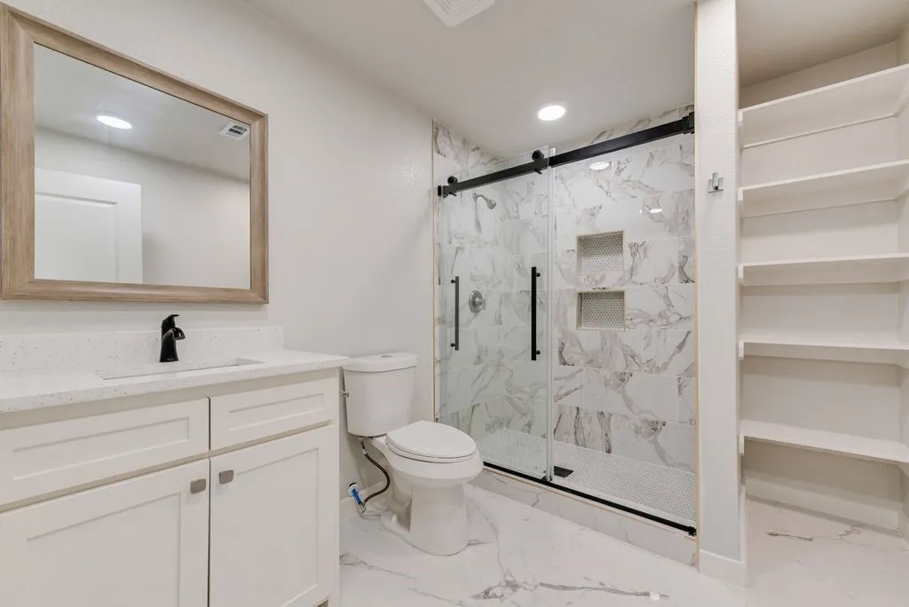 White vanity with a quartz countertop and integrated sink