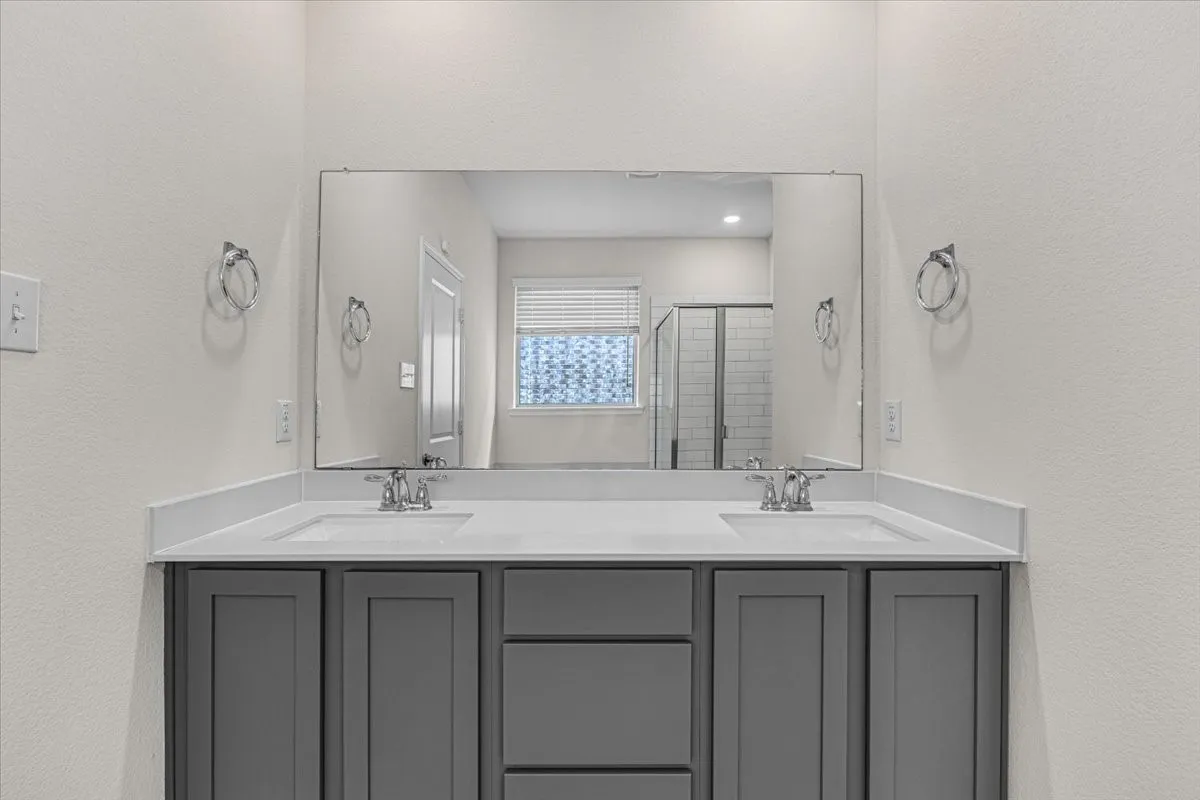 Master bath with dual sinks and elegant gray cabinets