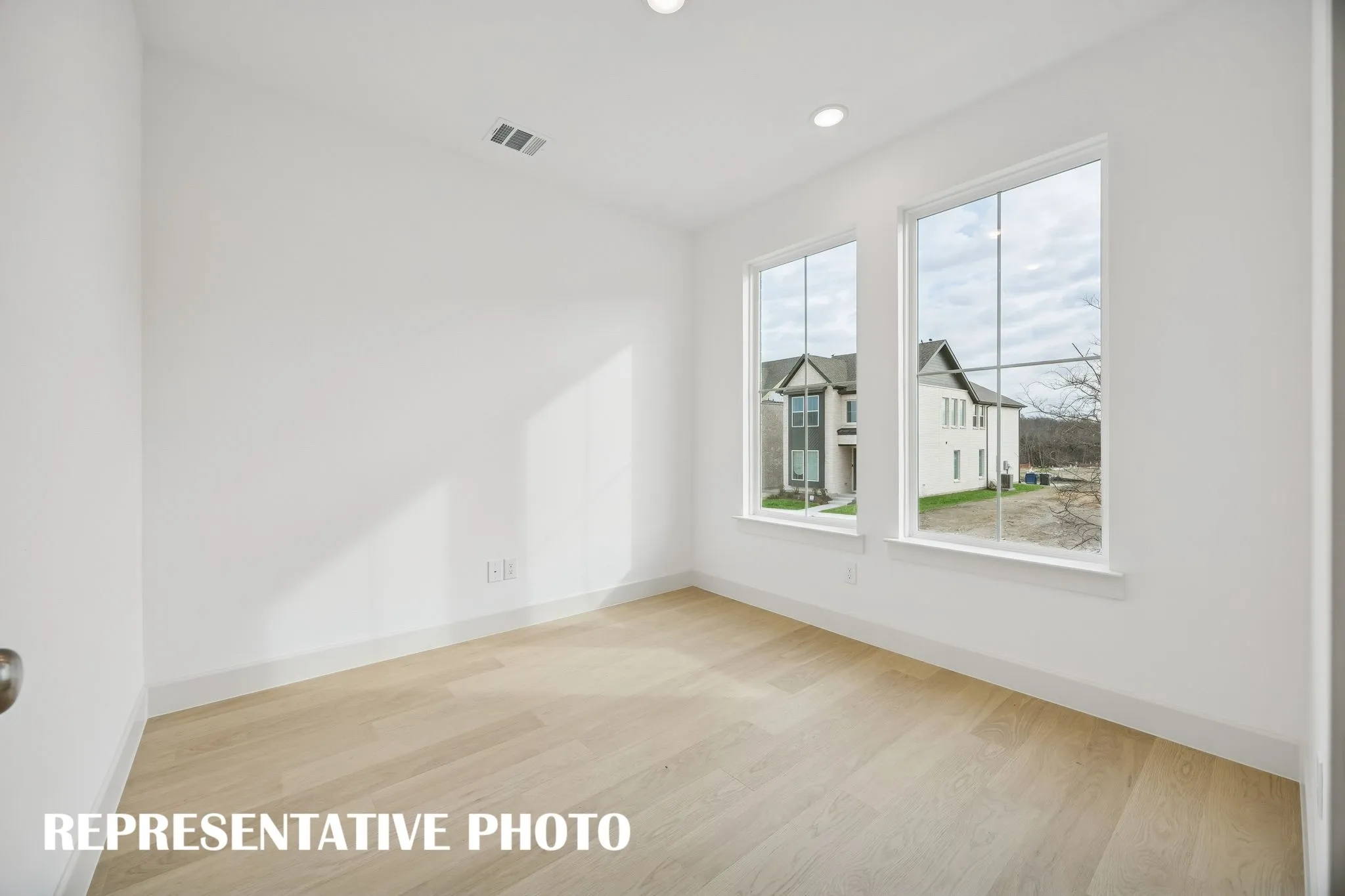 The professional working from home will appreciate this private home office with oversized windows providing tons of natural light.  REPRESENTATIVE PHOTO