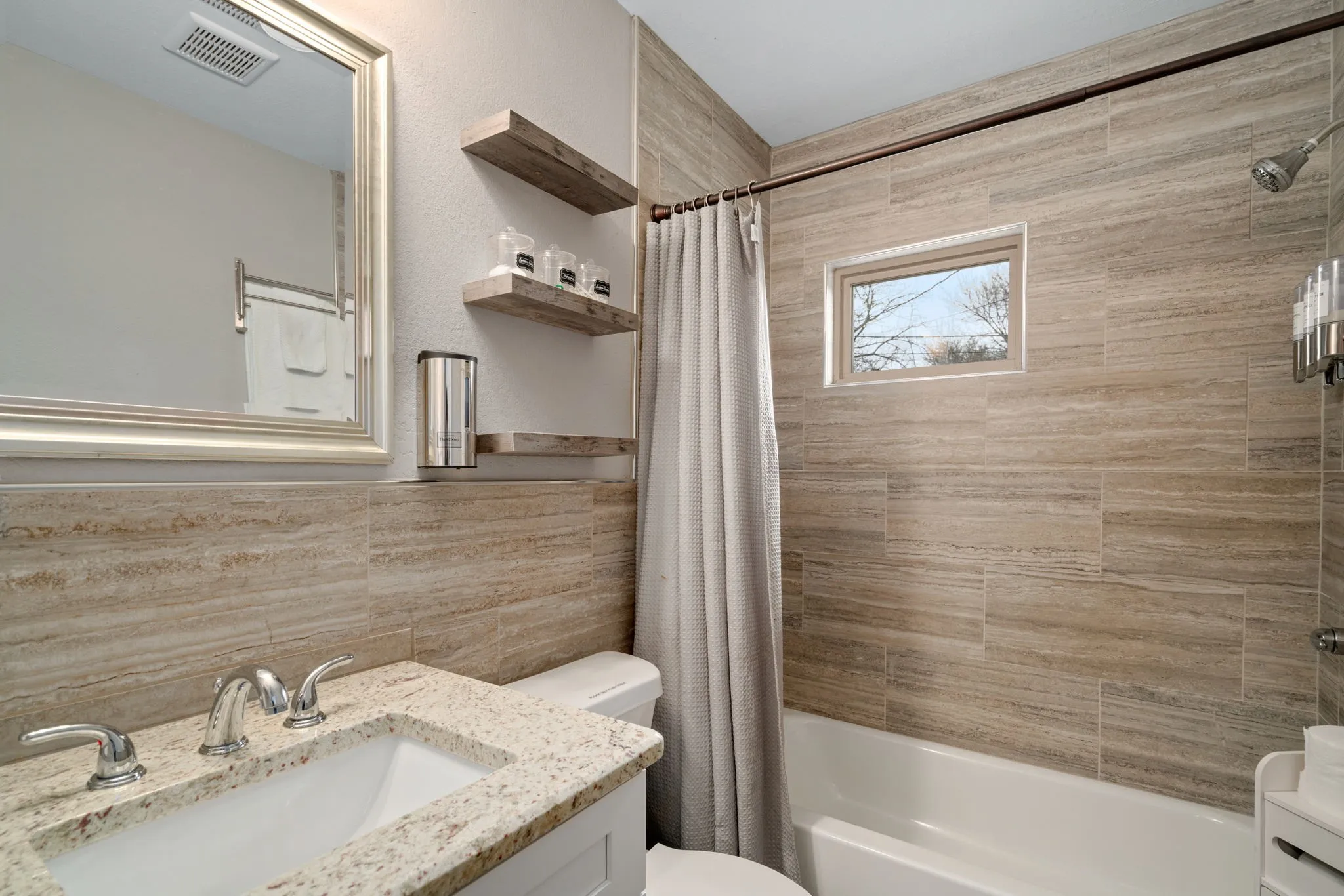 Vanity with a granite countertop, undermount sink, and chrome fixtures