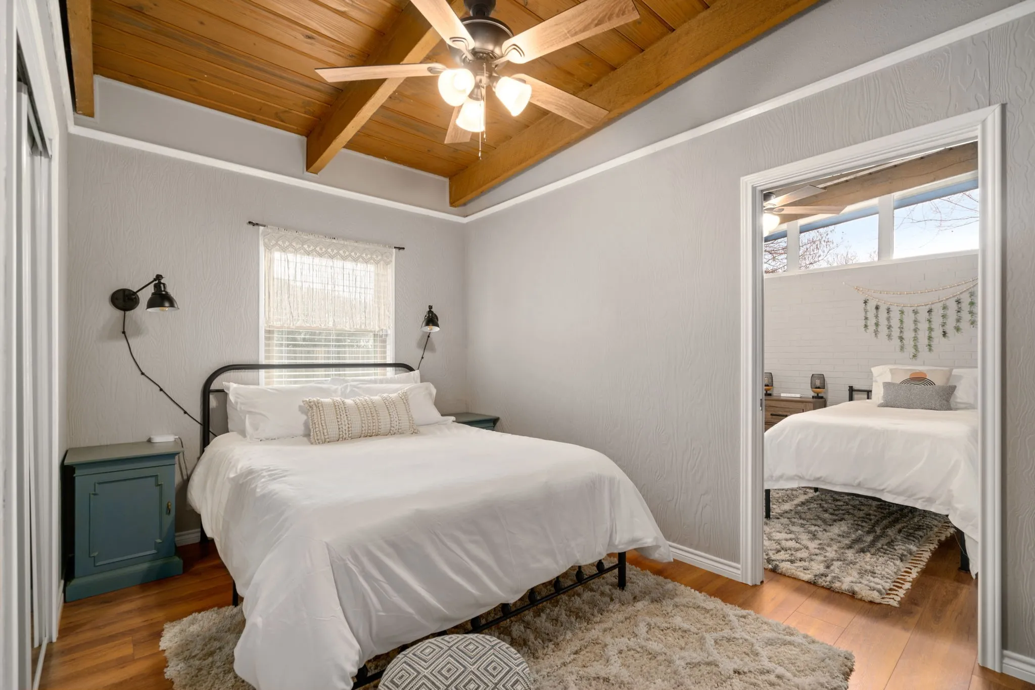 Wood-finish flooring with a vaulted wood-paneled ceiling, complemented by a ceiling fan with integrated lighting