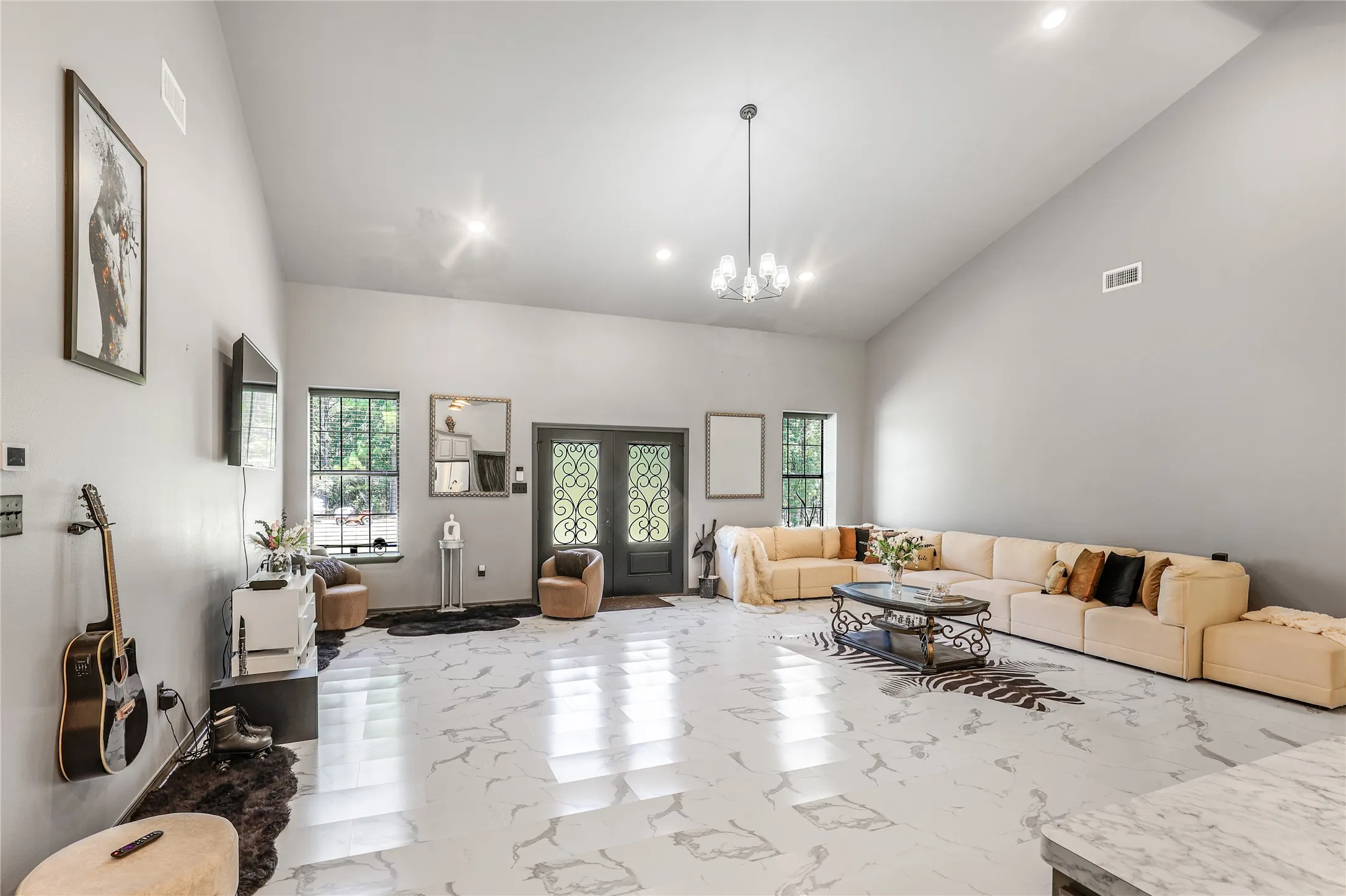 Vaulted ceiling with an attached chandelier and recessed lighting