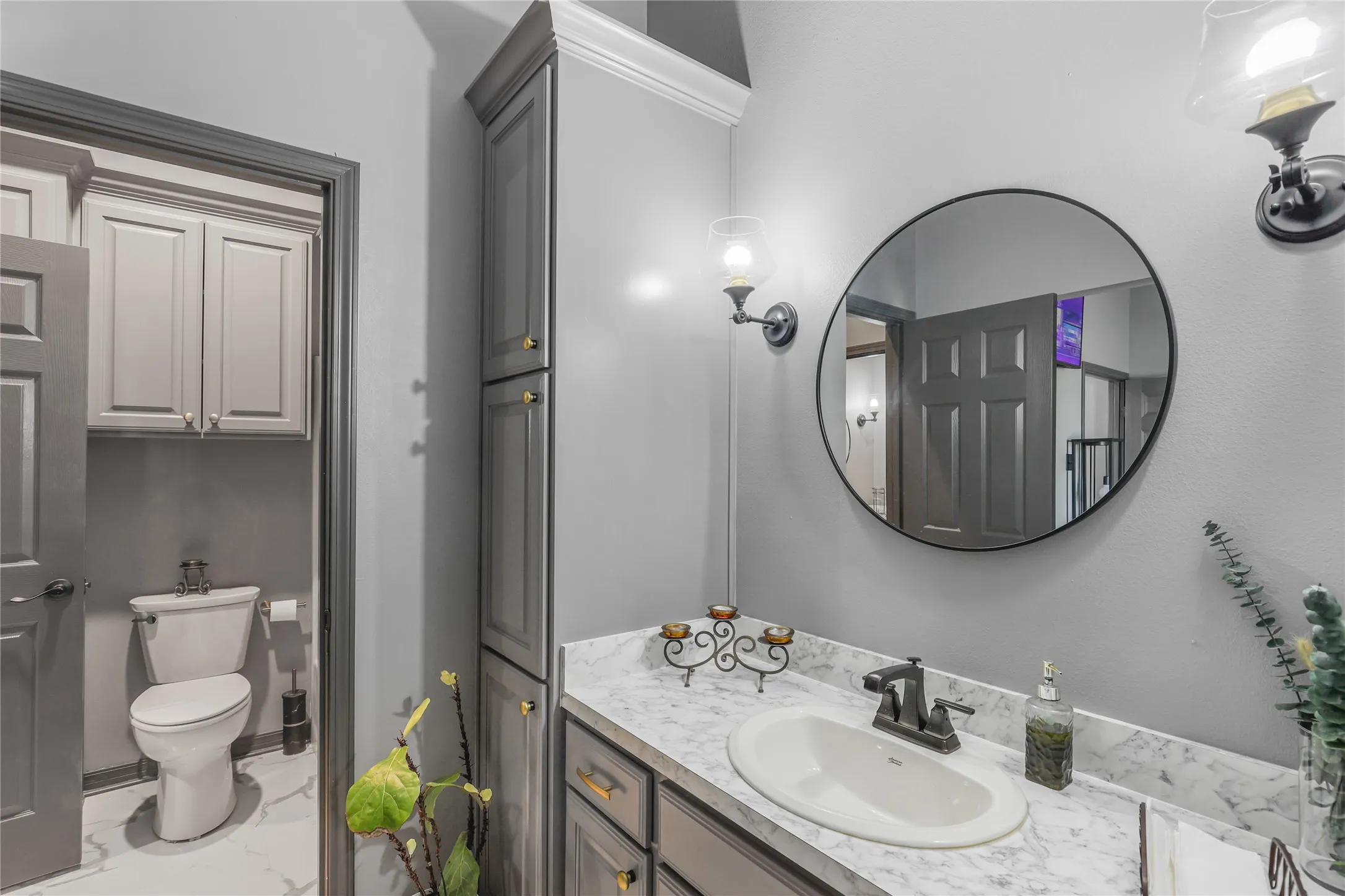 Vanity with undermount sink, dark bronze faucet, and stone-finish countertop