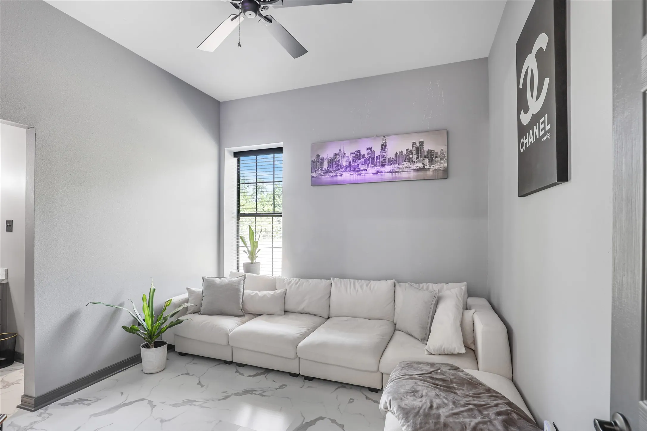 White tile flooring with gray veining, gray painted walls, and a window with black blinds