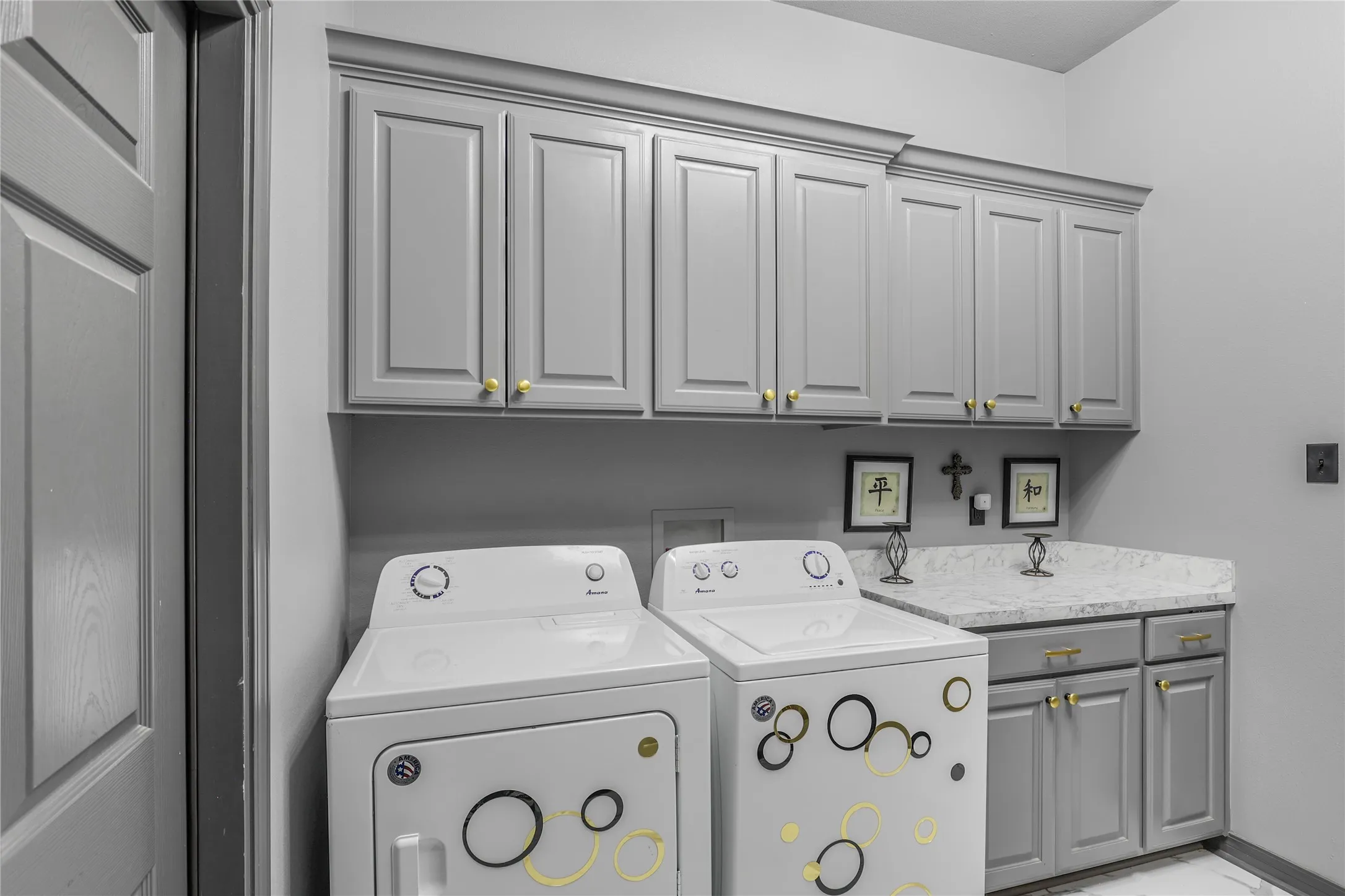 Upper and lower cabinetry with gold-toned hardware, solid-surface countertop