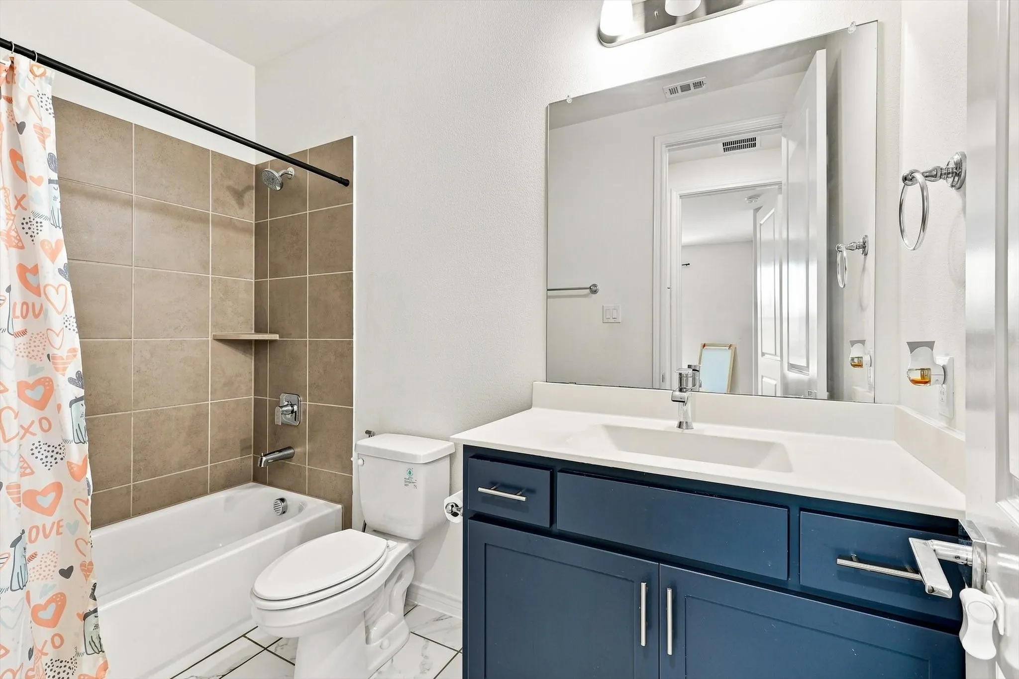 White tub with chrome fixtures and tan tile surround