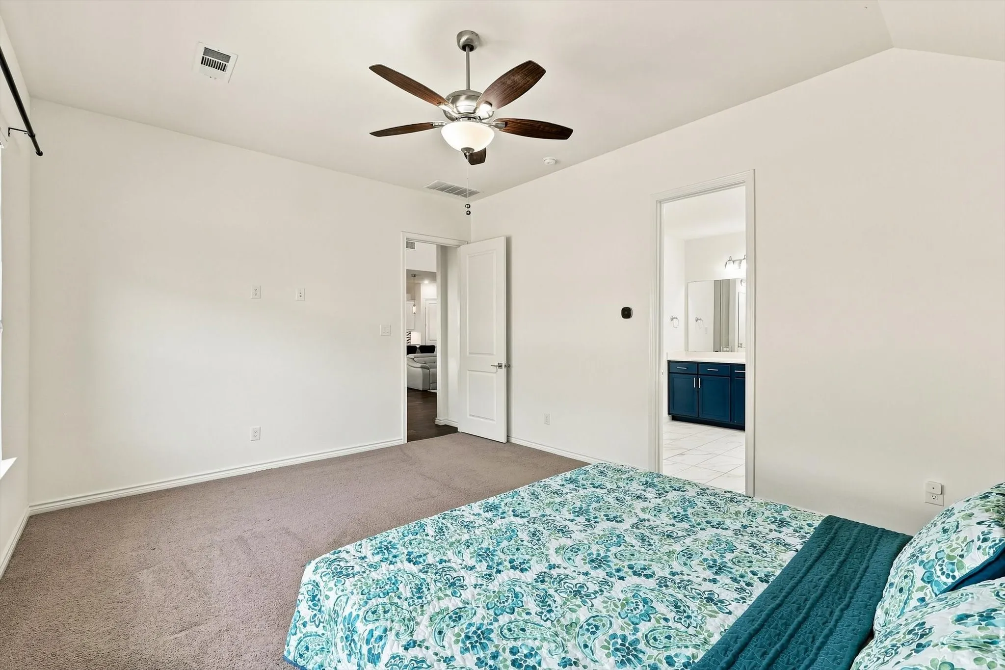 Vaulted ceiling with a ceiling fan, neutral carpet, and white walls