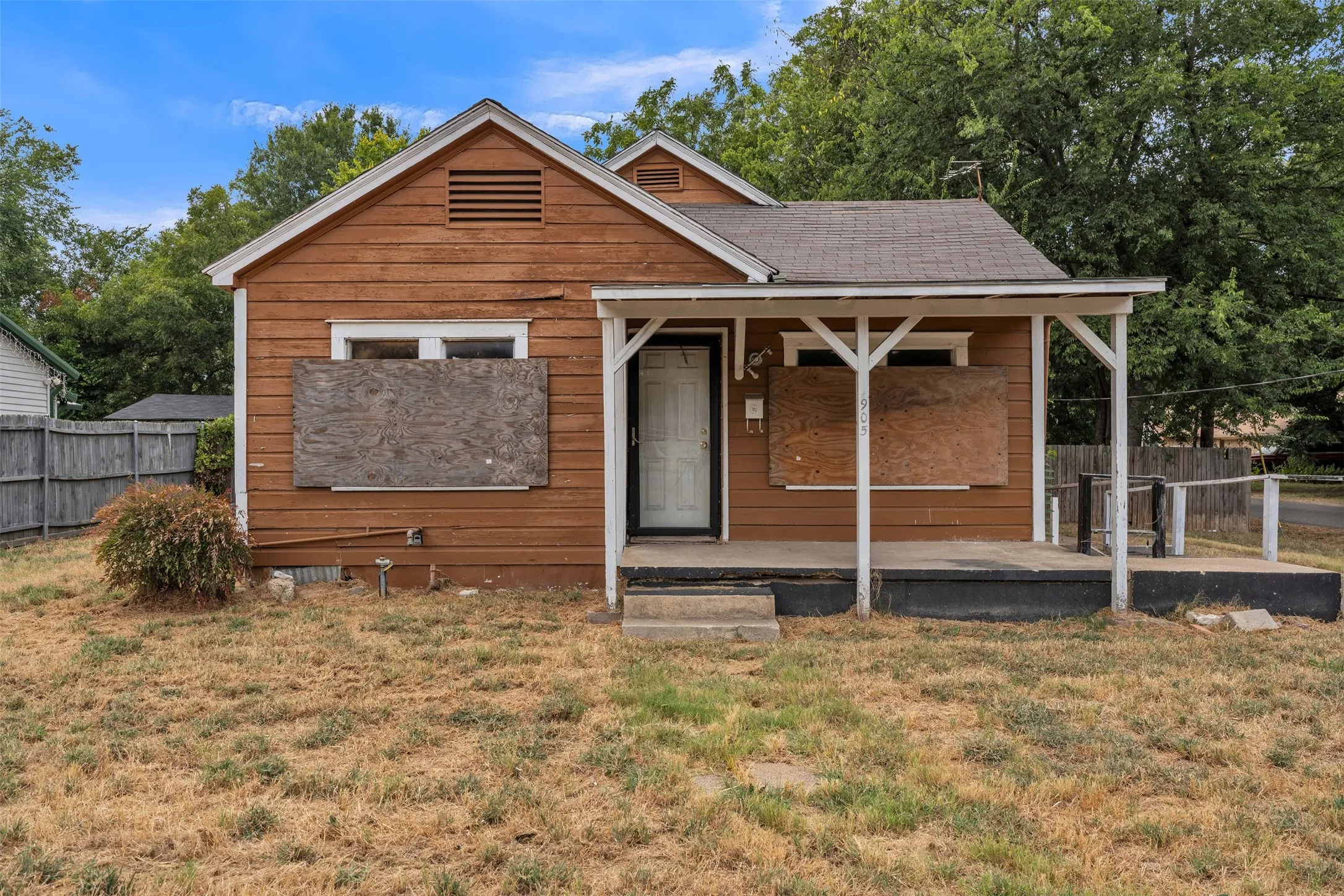 Wood-sided exterior with a covered front porch featuring white support posts