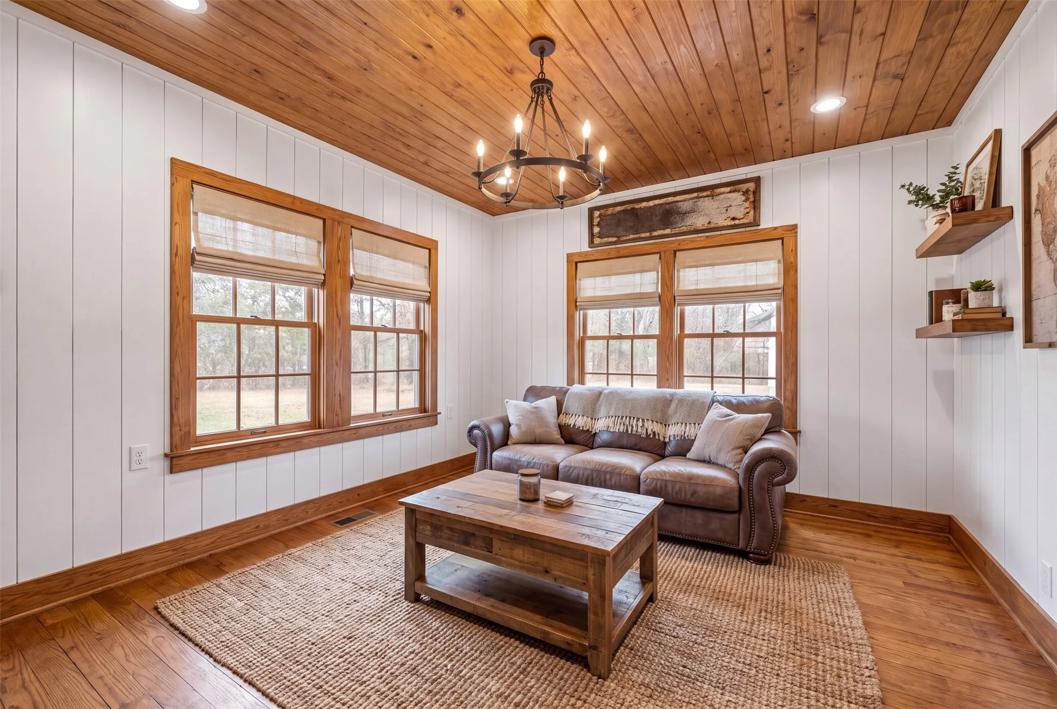 Virtually Altered. Wood-plank ceiling with recessed lighting and a wrought iron chandelier