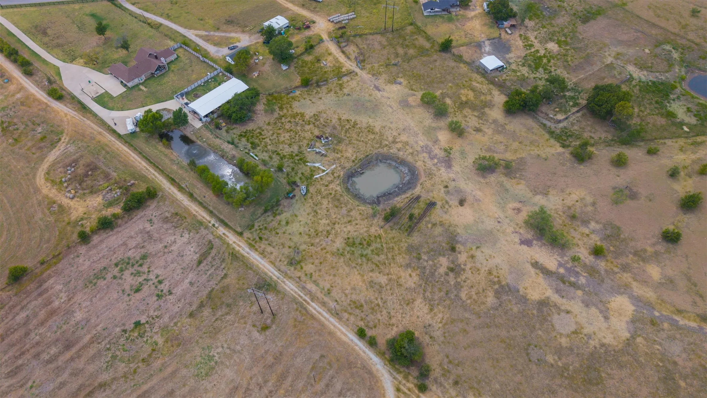 Expansive property featuring a private pond, additional water feature, and a substantial outbuilding