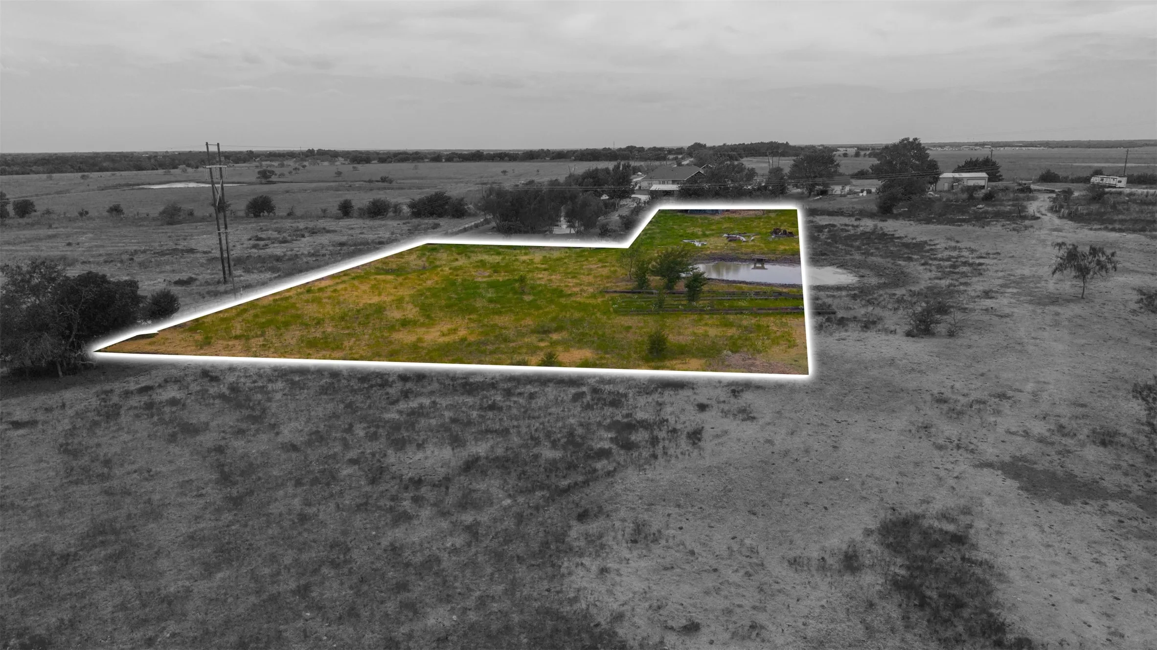 Expansive land parcel with a natural pond and varying levels of vegetation