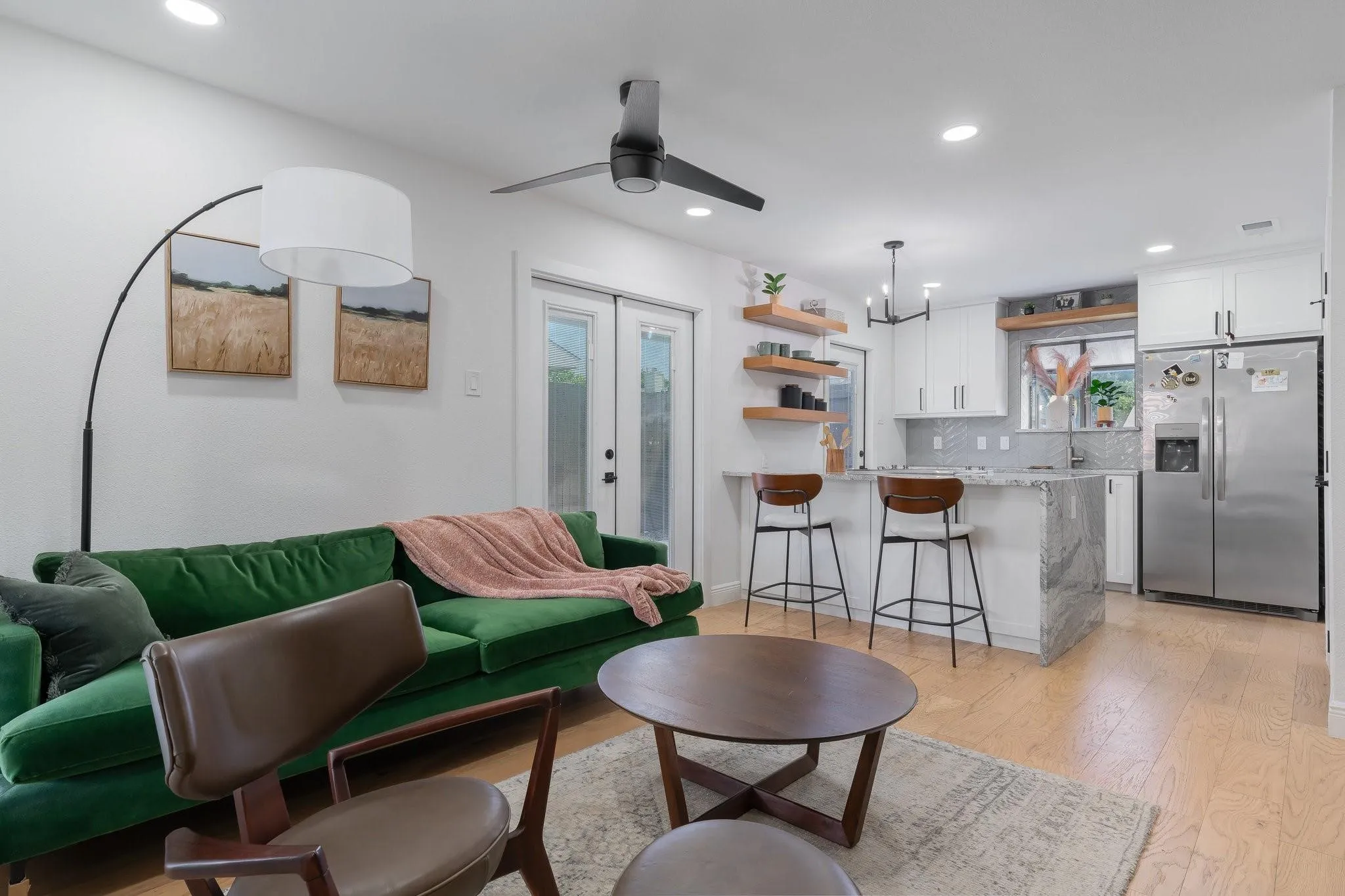 Recessed lighting, wood-finish flooring, ceiling fan, white cabinetry, and stainless steel refrigerator