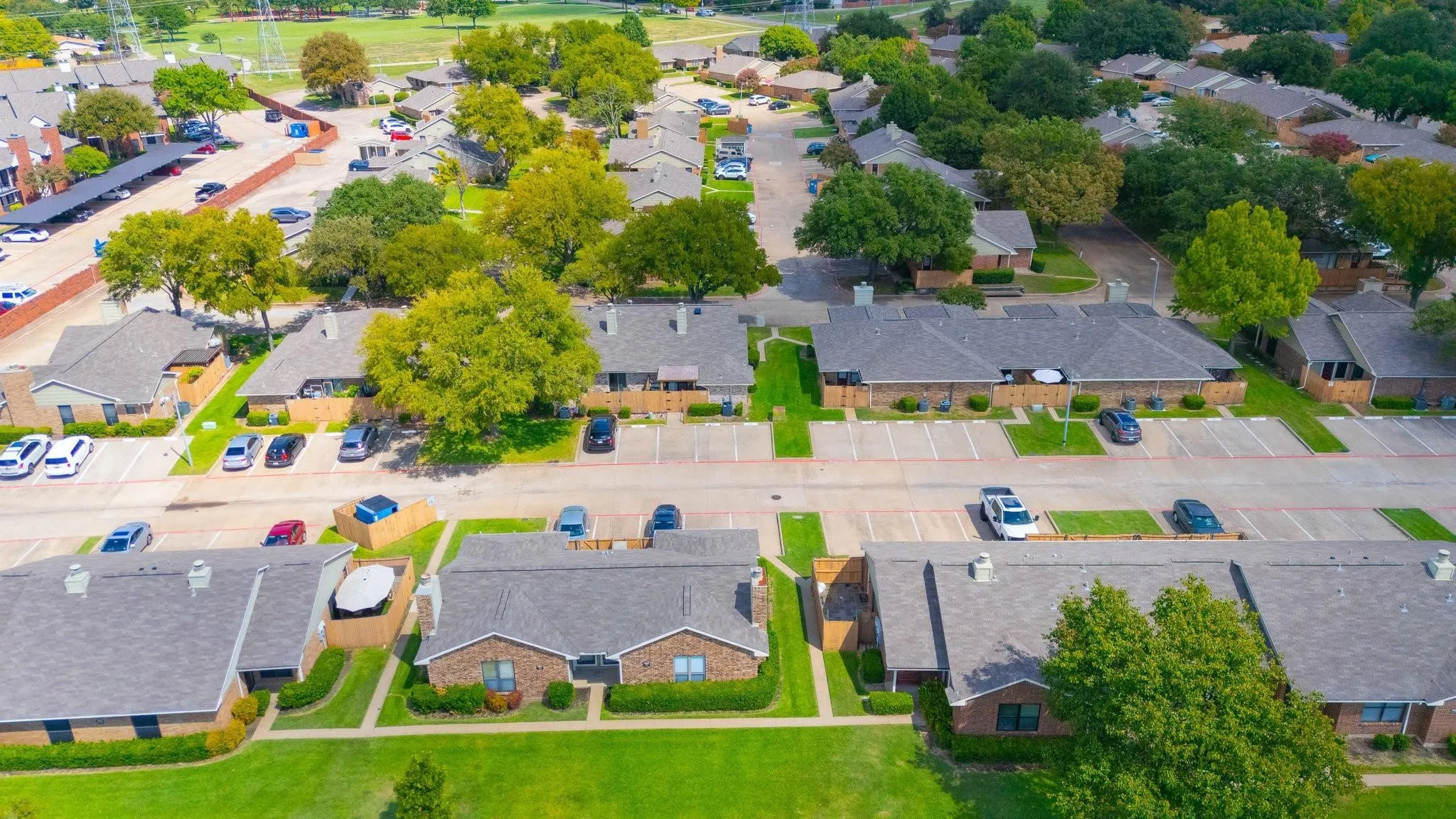 Aerial perspective showcasing a residential community with abundant mature trees and manicured green spaces