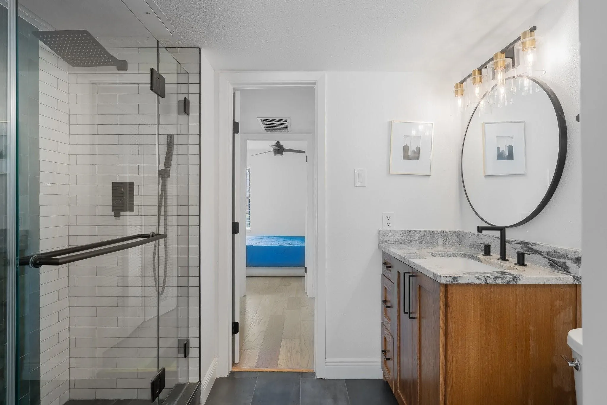 Glass-enclosed shower with subway tile surround and dark-finish fixtures