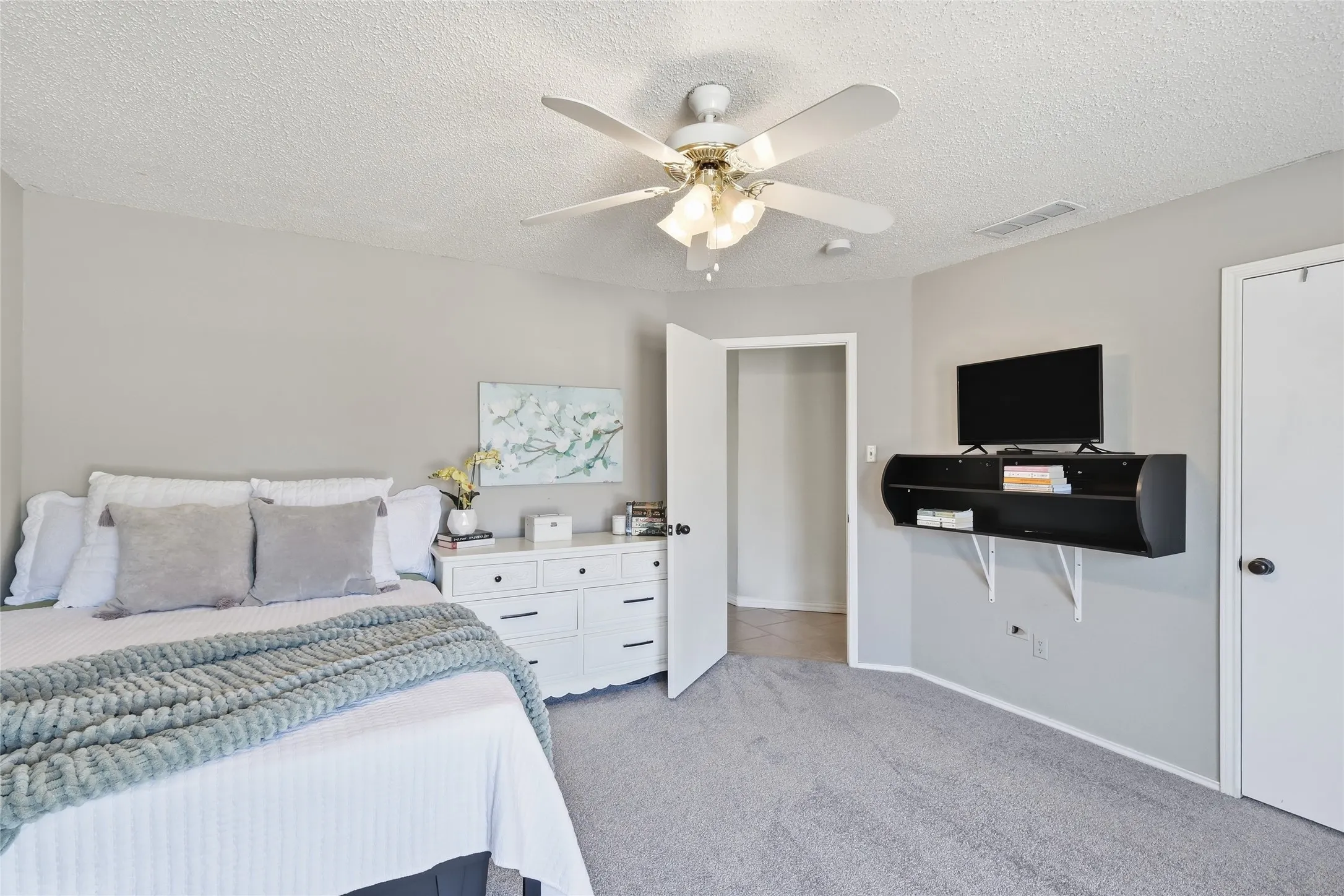 Neutral wall color, wall-to-wall carpeting, ceiling fan with light fixture, white interior doors, built-in shelving