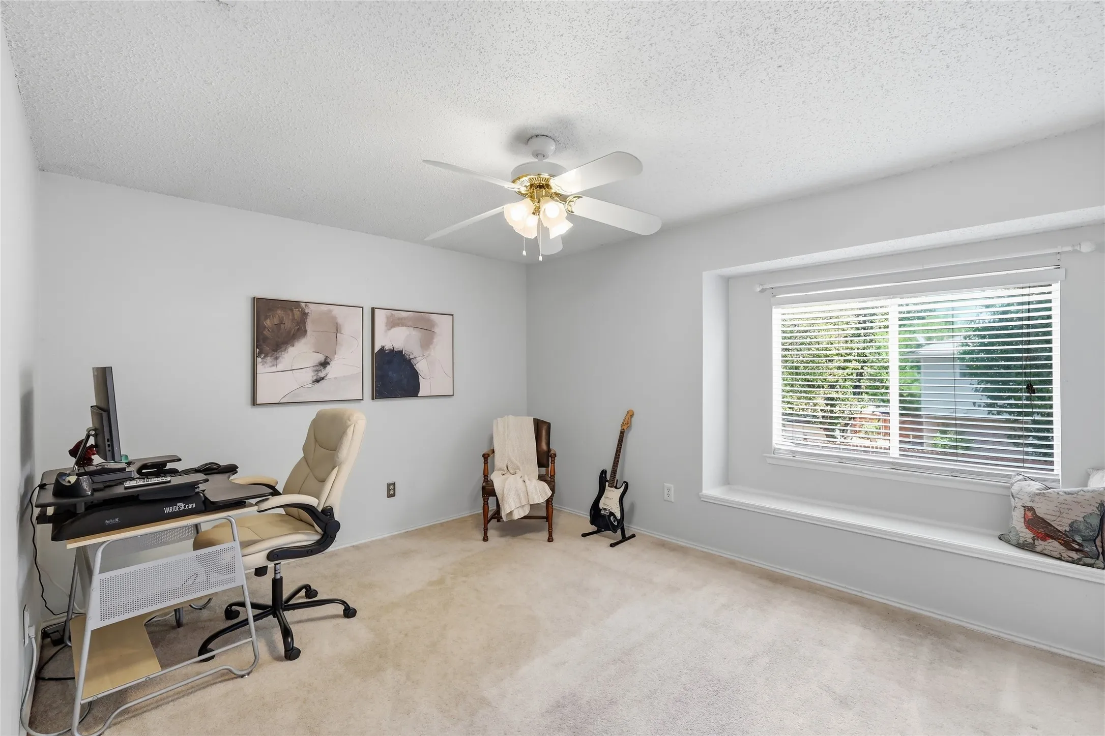 Recessed window with built-in bench seating, ceiling fan with light fixture, and neutral carpeting