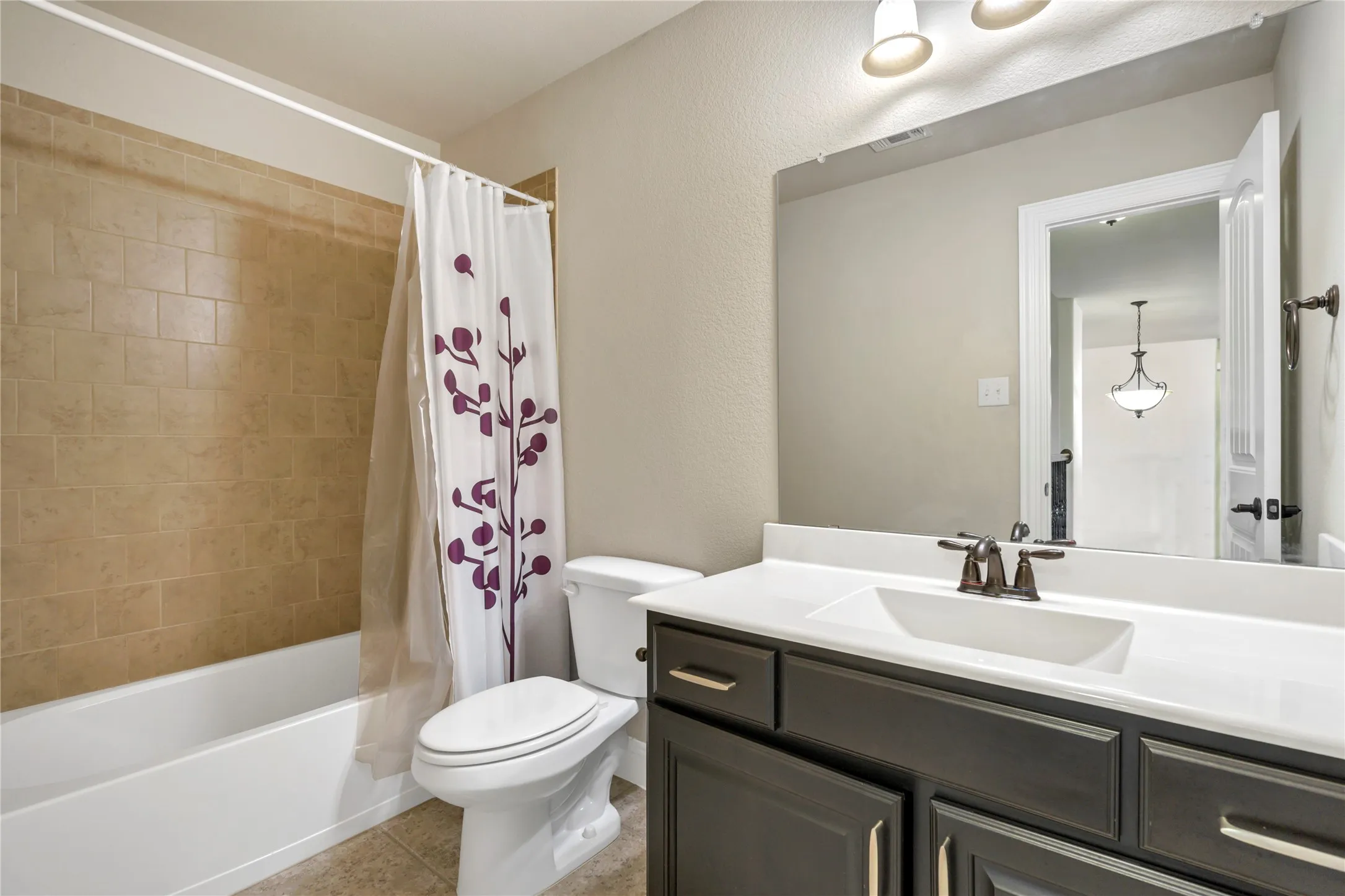 Built-in vanity with dark wood-finish cabinetry, integrated sink, and bronze-finish fixtures