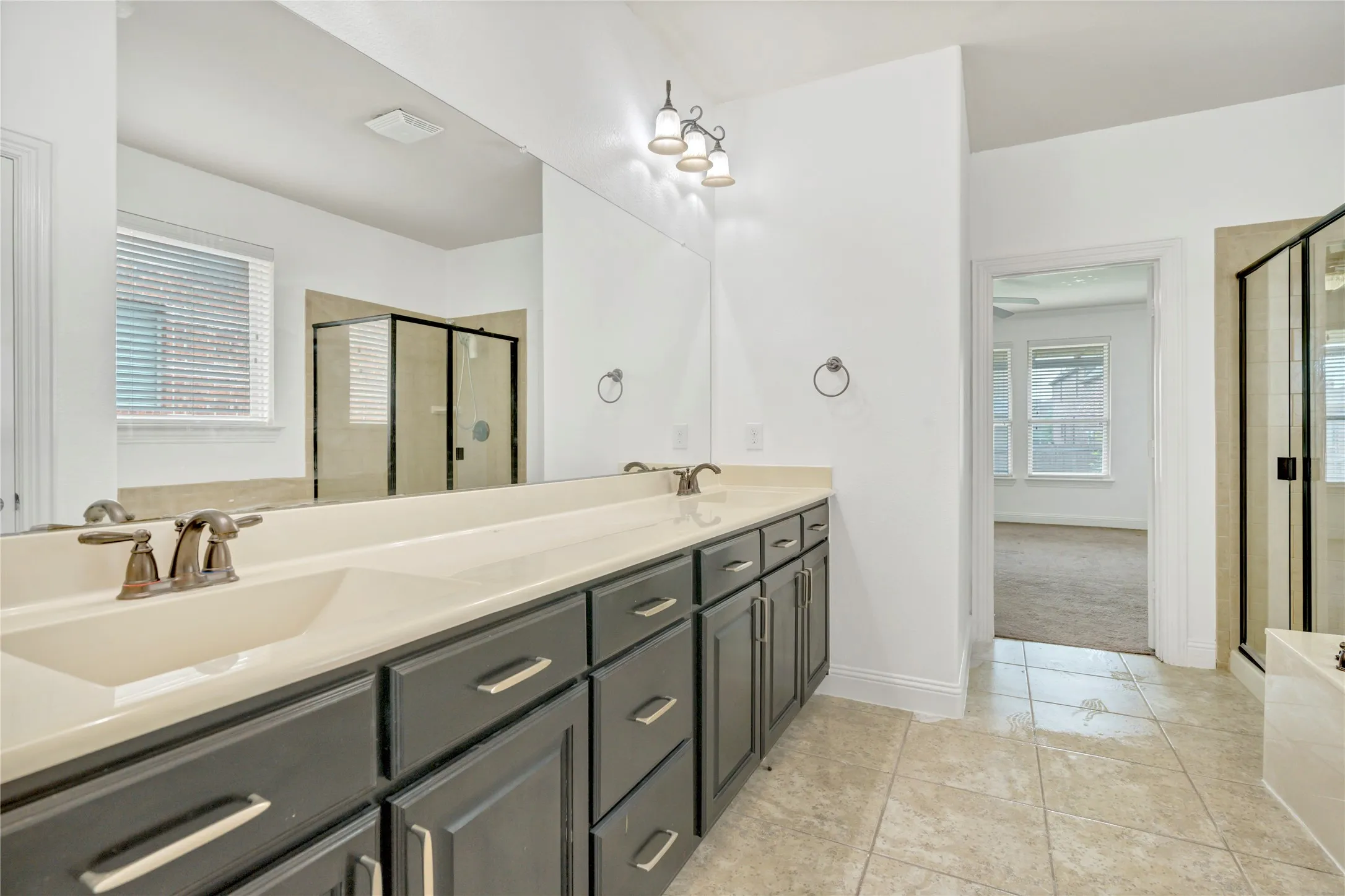 Dual vanity with integrated sinks, dark wood-finish cabinetry, and brushed nickel fixtures