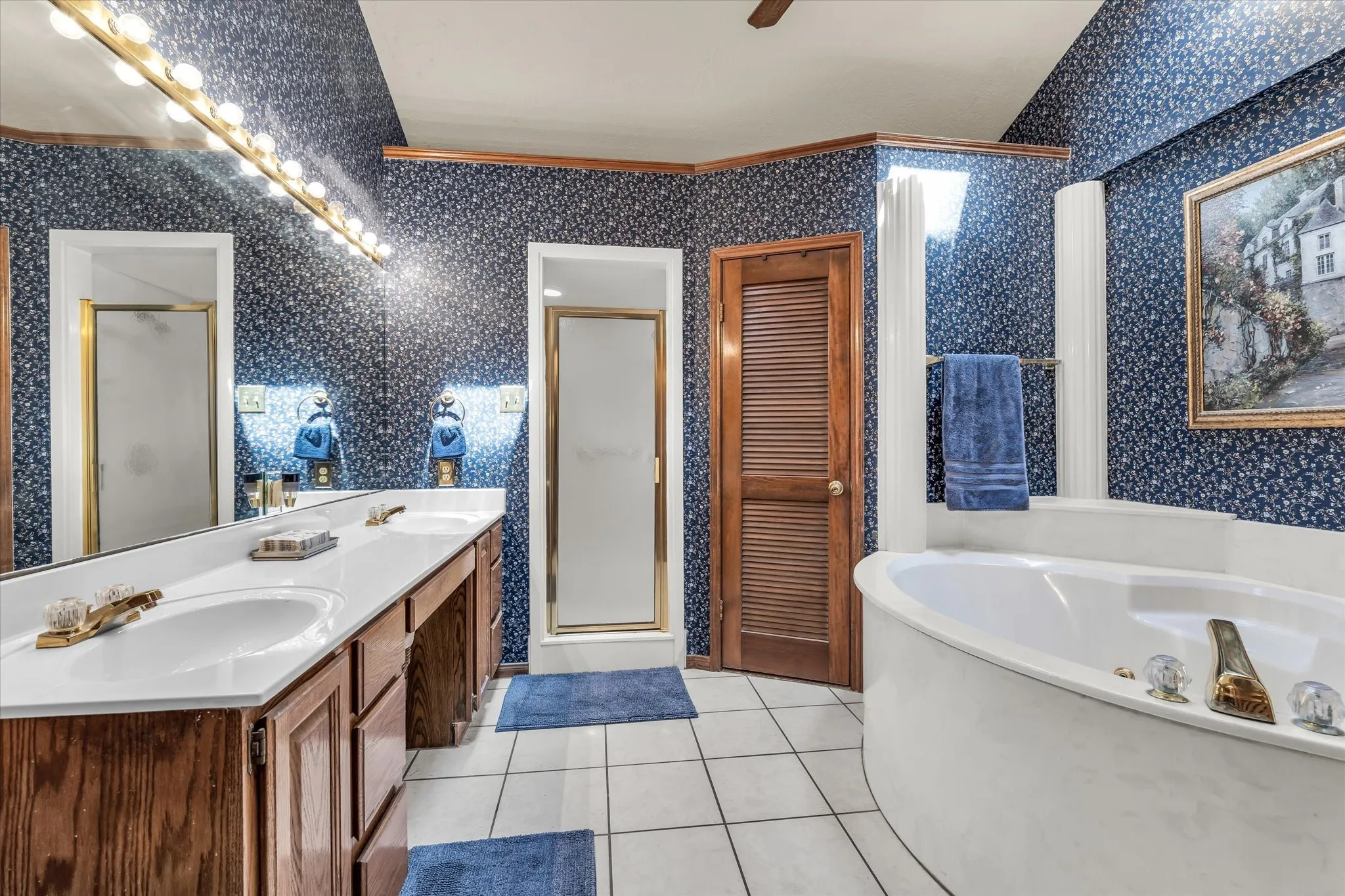Double vanity with built-in cabinetry, large mirror, and overhead lighting