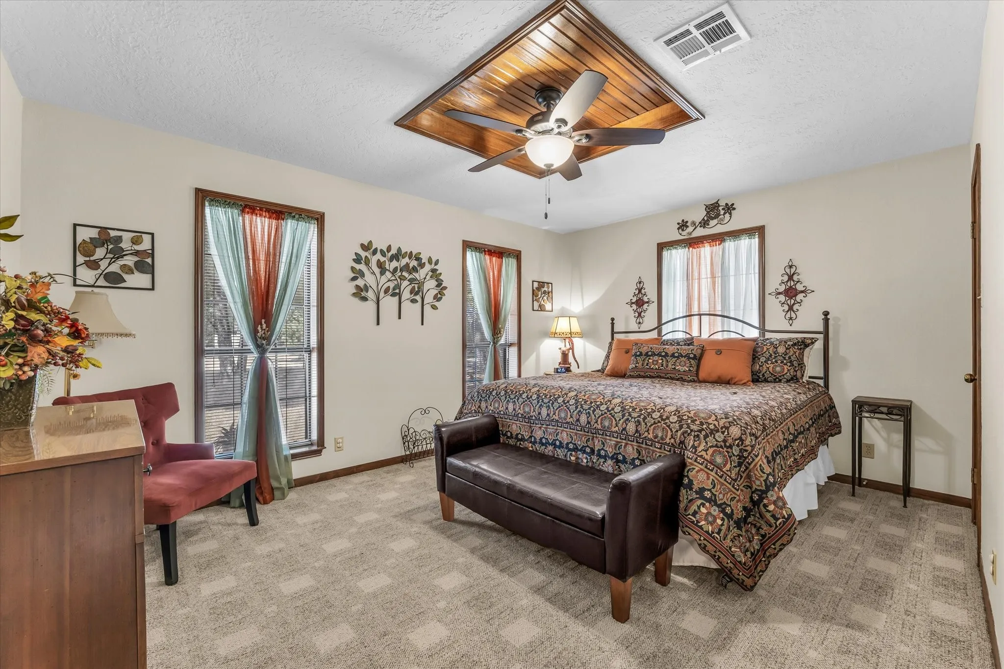 Recessed ceiling detail with wood-finish paneling and a ceiling fan