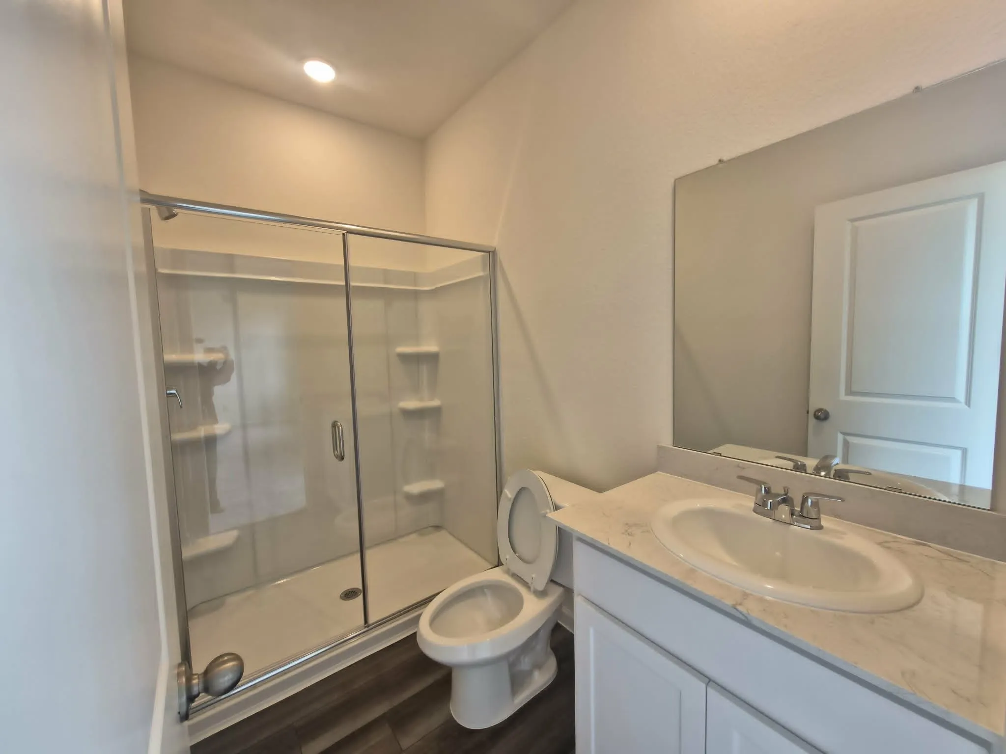 White vanity with a single basin sink, chrome faucet, and integrated countertop