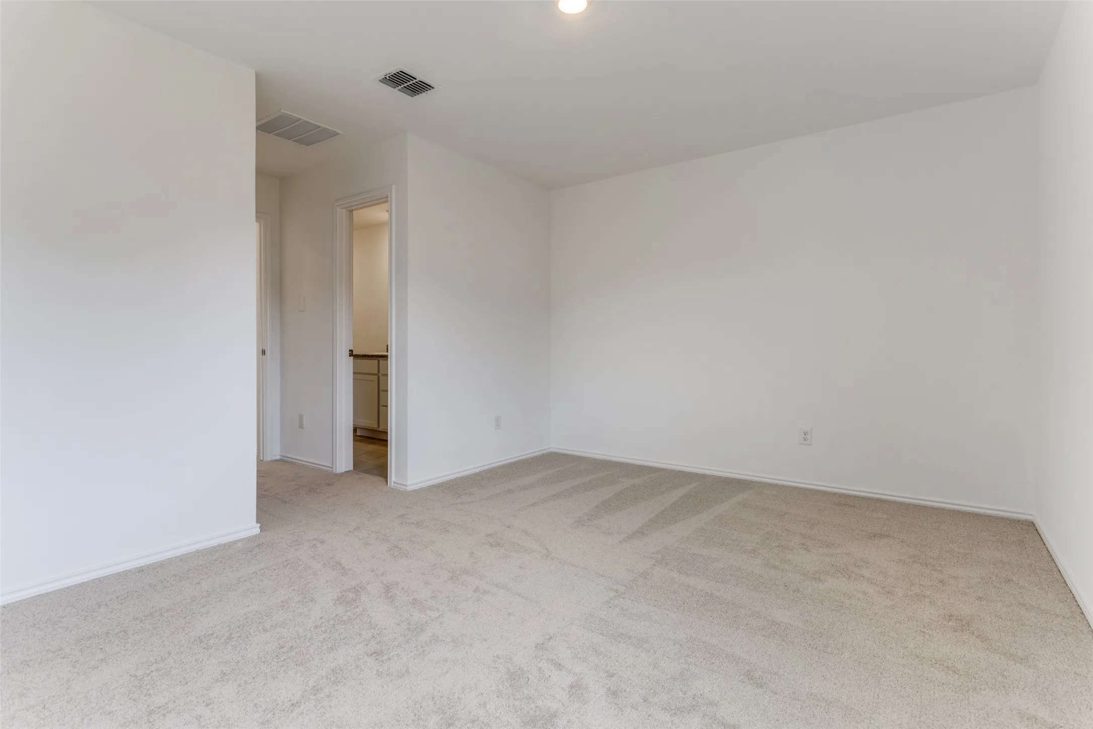 Empty room featuring light colored carpet