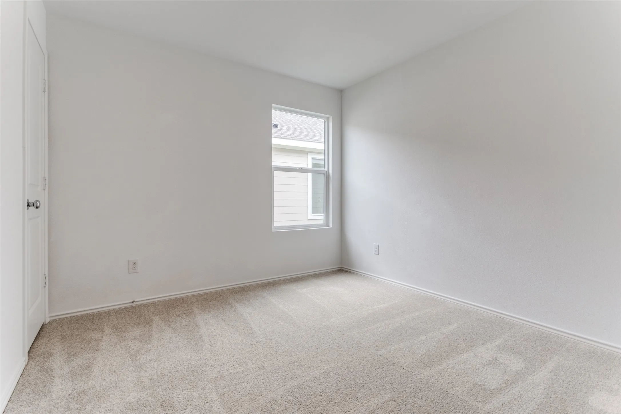 Unfurnished room featuring light carpet