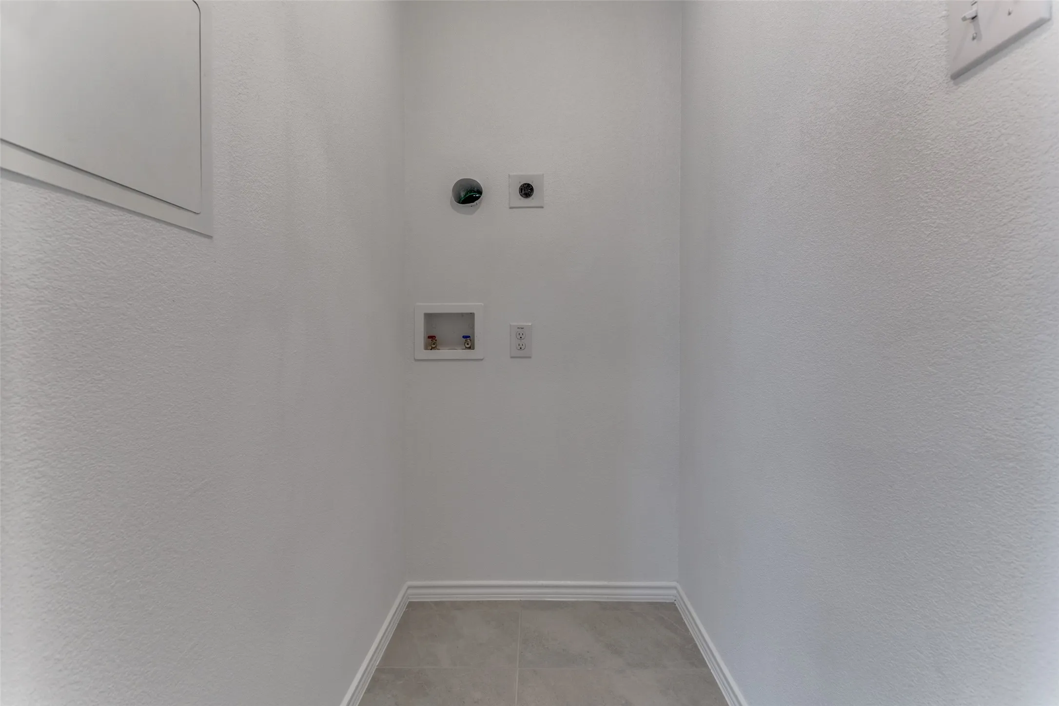 Washroom featuring hookup for an electric dryer, tile floors, and washer hookup