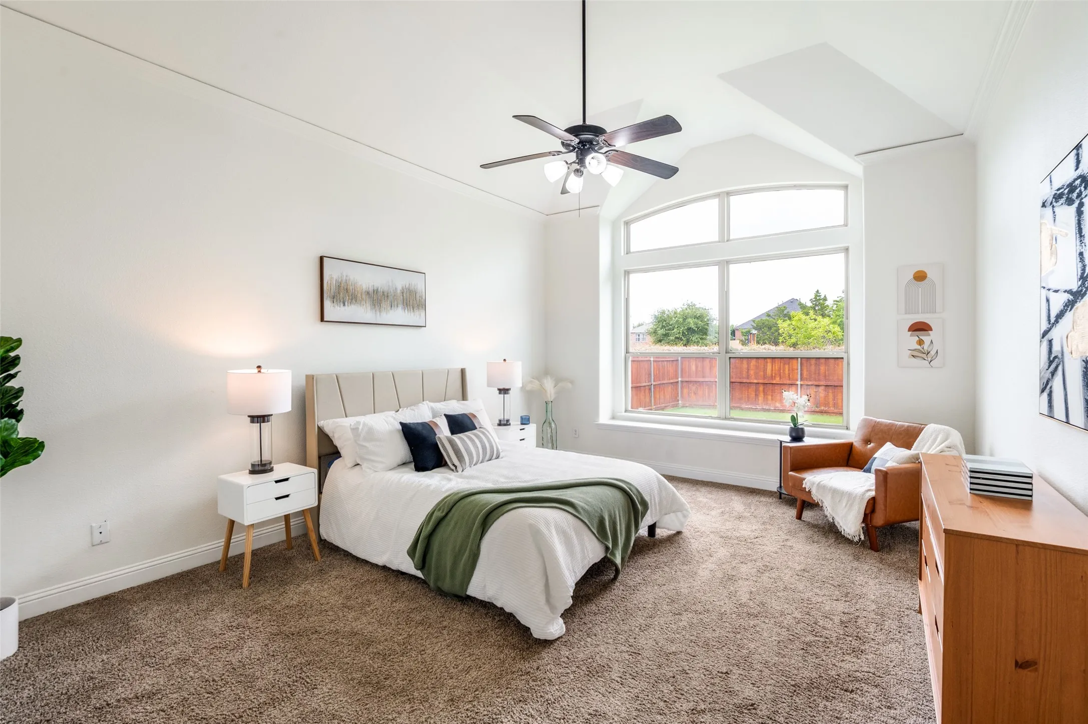 Arched picture window, recessed ceiling, ceiling fan, and carpeted flooring