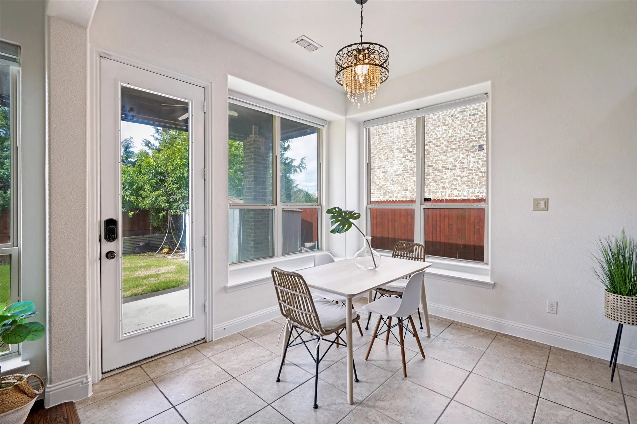 Tiled flooring, multiple large windows, and a glass-paneled exterior door