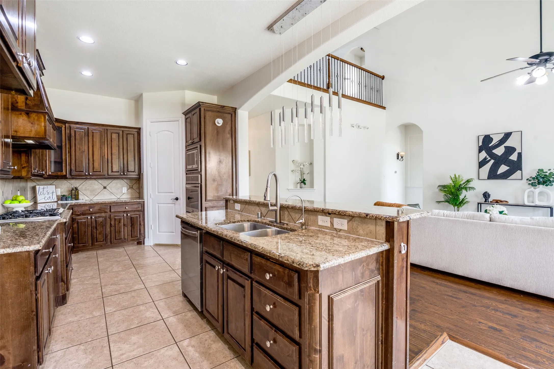 Kitchen featuring wood cabinetry, granite countertops, tile flooring, and stainless steel appliances