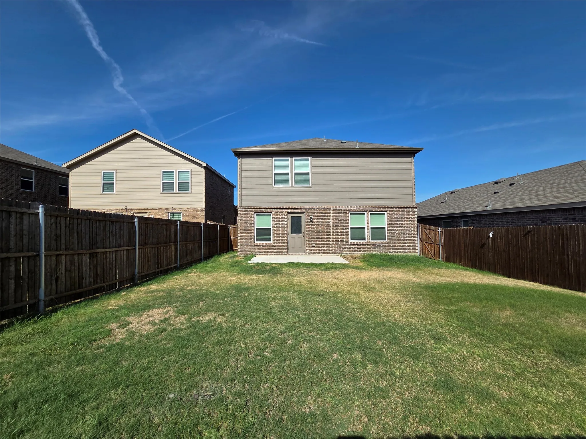 Expansive grassy yard with a privacy fence