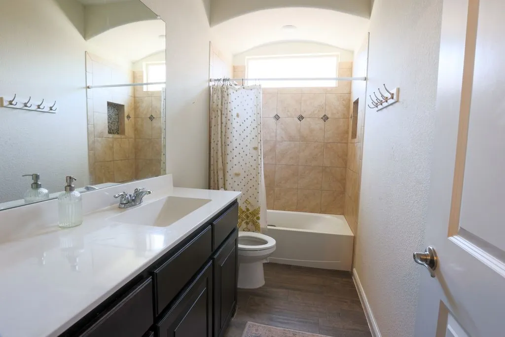 Single vanity with a white countertop and dark cabinetry
