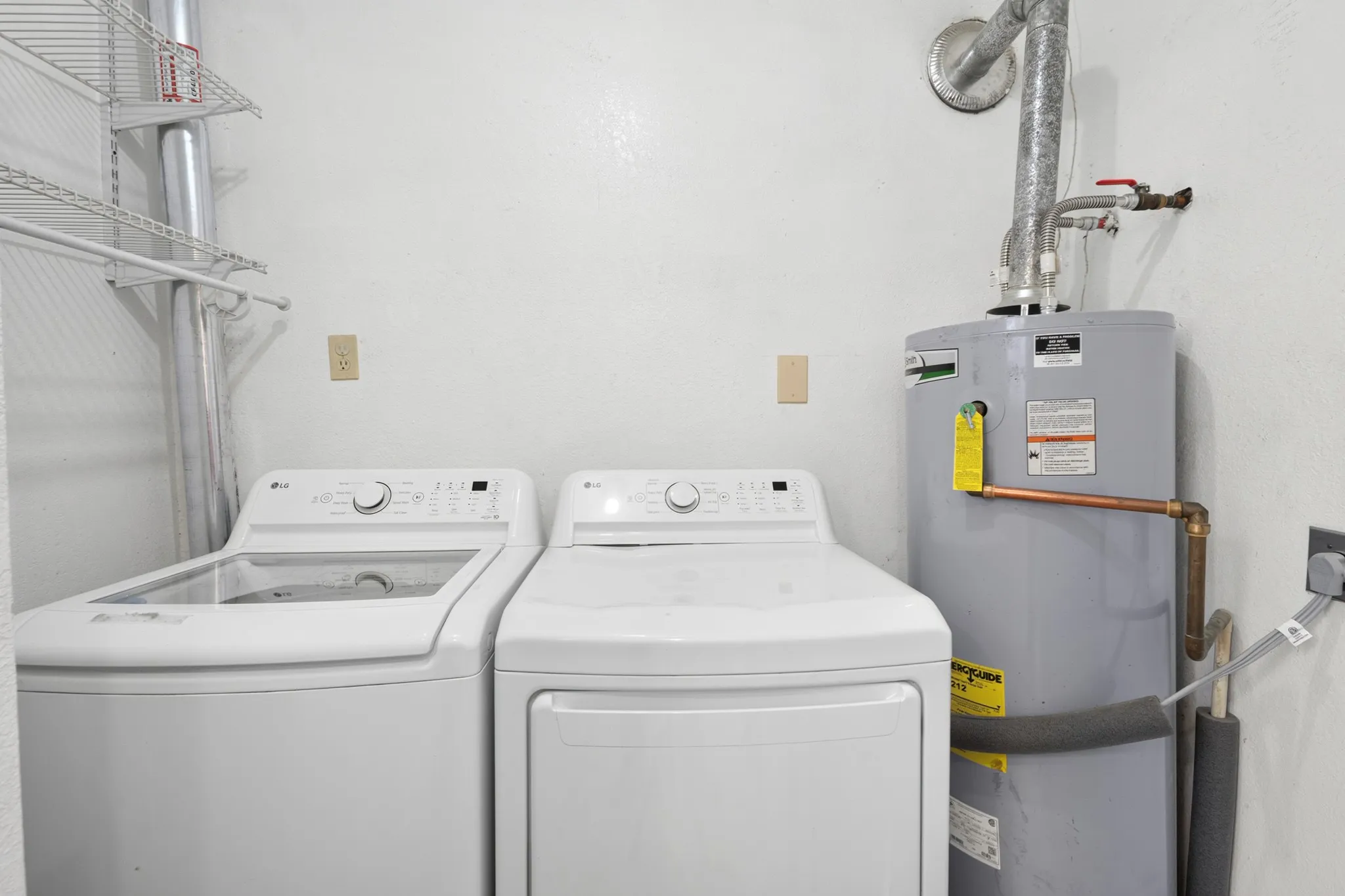 Laundry area with wire shelving and a water heater