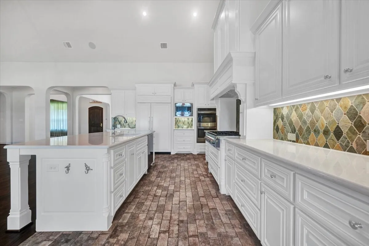 Pristine white kitchen with ample cabinetry & under counter lighting
