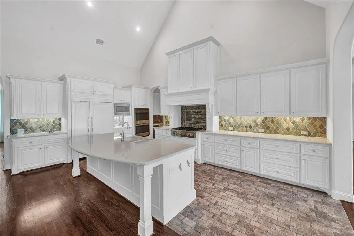 Kitchen with brick pavers, GE Profile double ovens, Dacor gas range, sub-zero fridge
