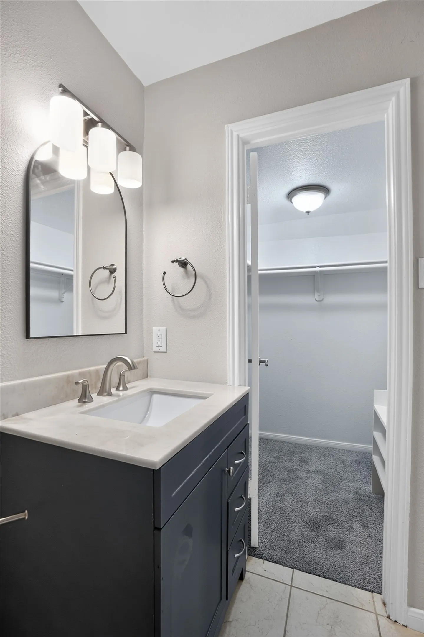 Vanity with a light-colored countertop, undermount sink, and brushed nickel faucet