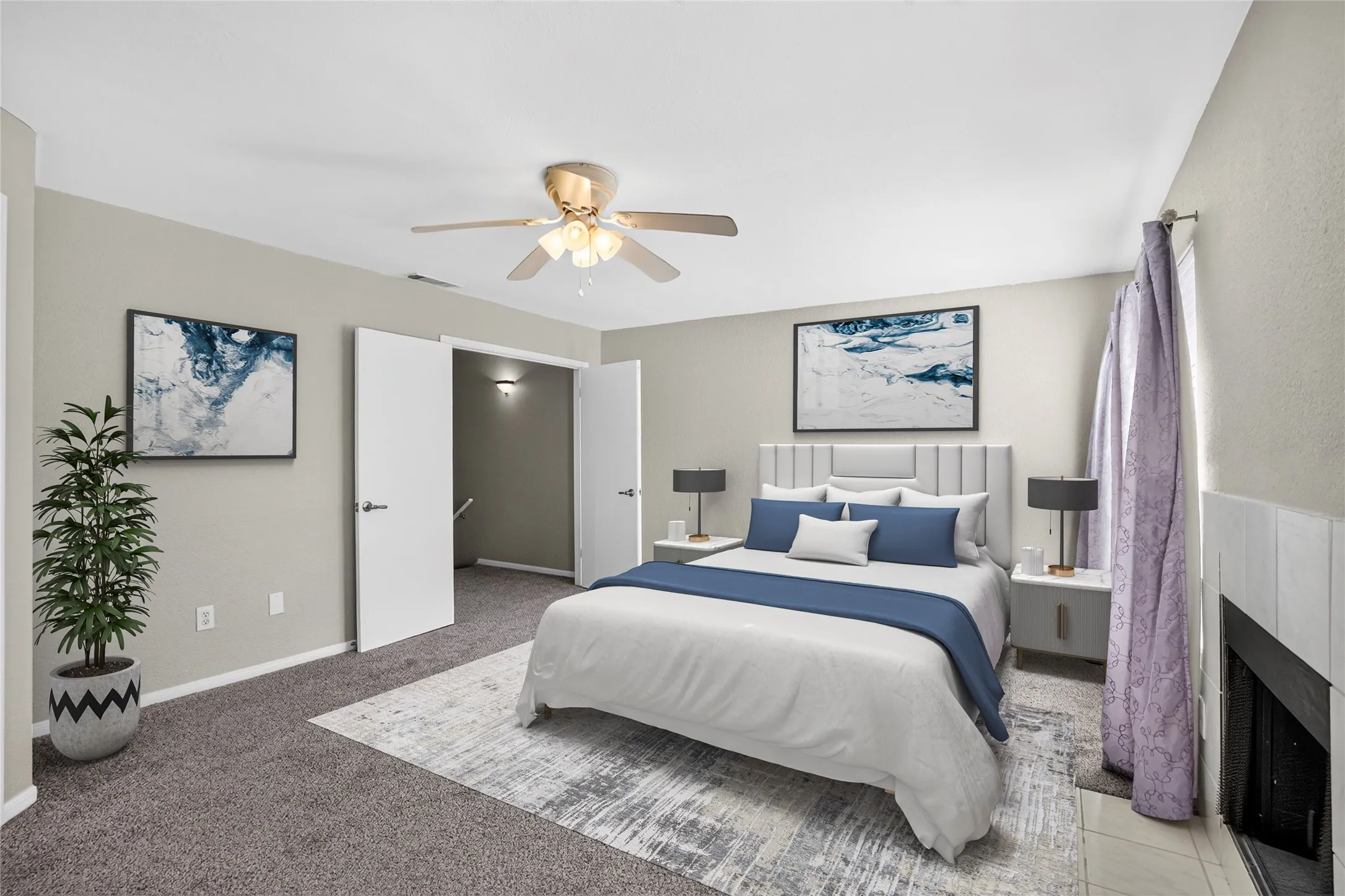 Carpeted flooring, ceiling fan with integrated lighting, white interior doors, and a tiled fireplace surround