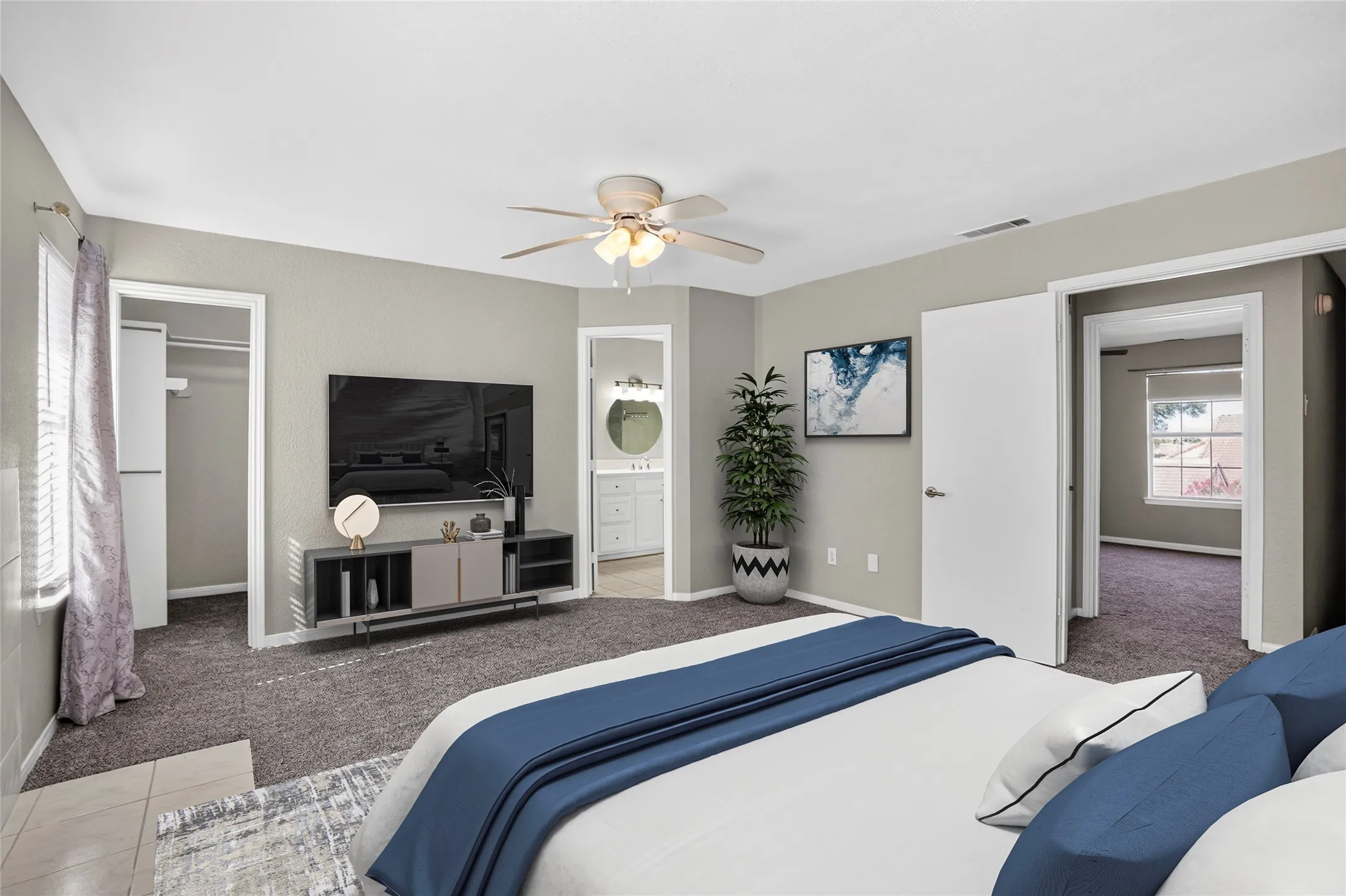 Carpeted flooring, ceiling fan, white paneled doors, and access to an additional room