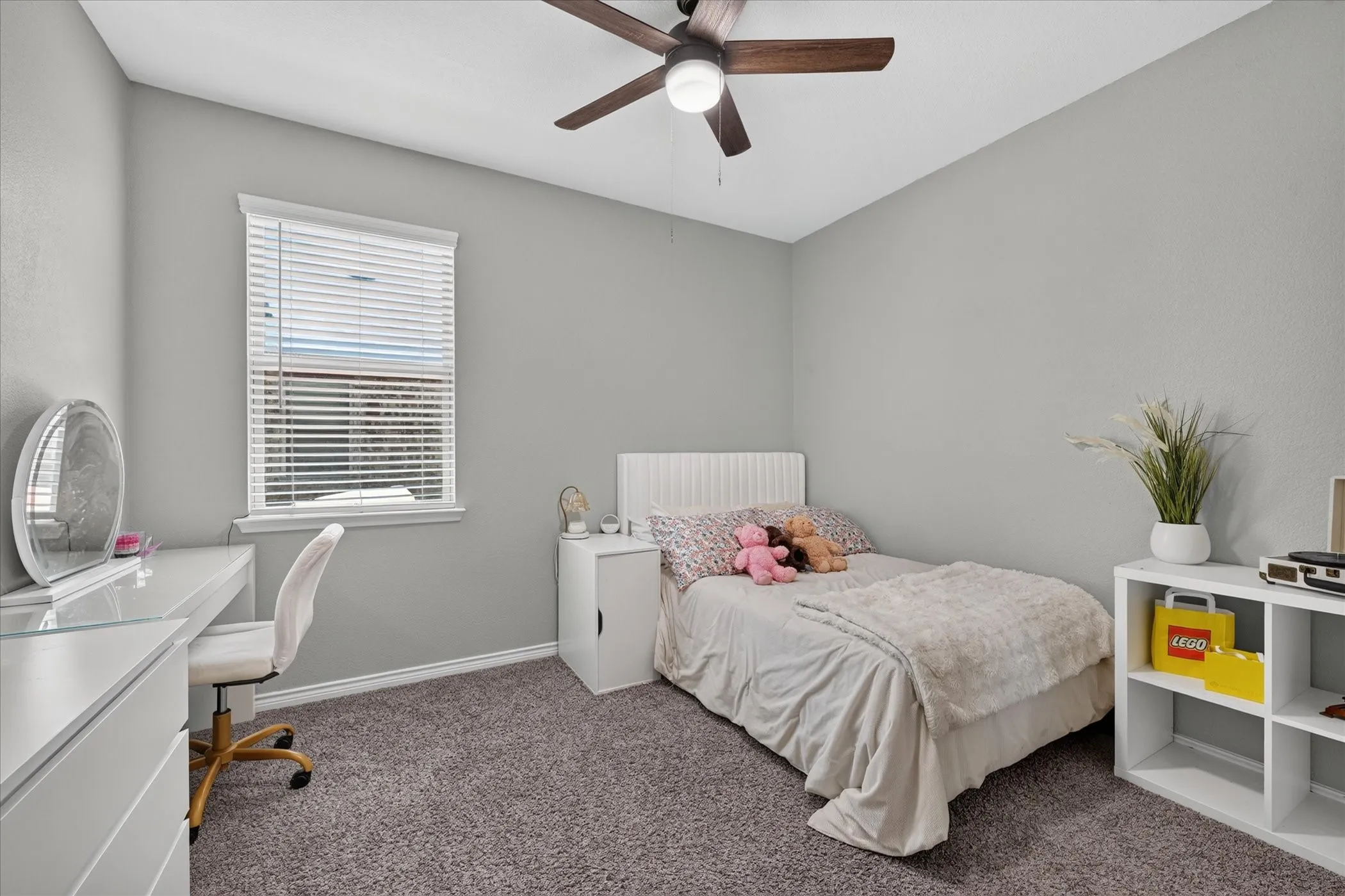 Recessed window with white blinds, wood-finish ceiling fan, and gray textured carpeting