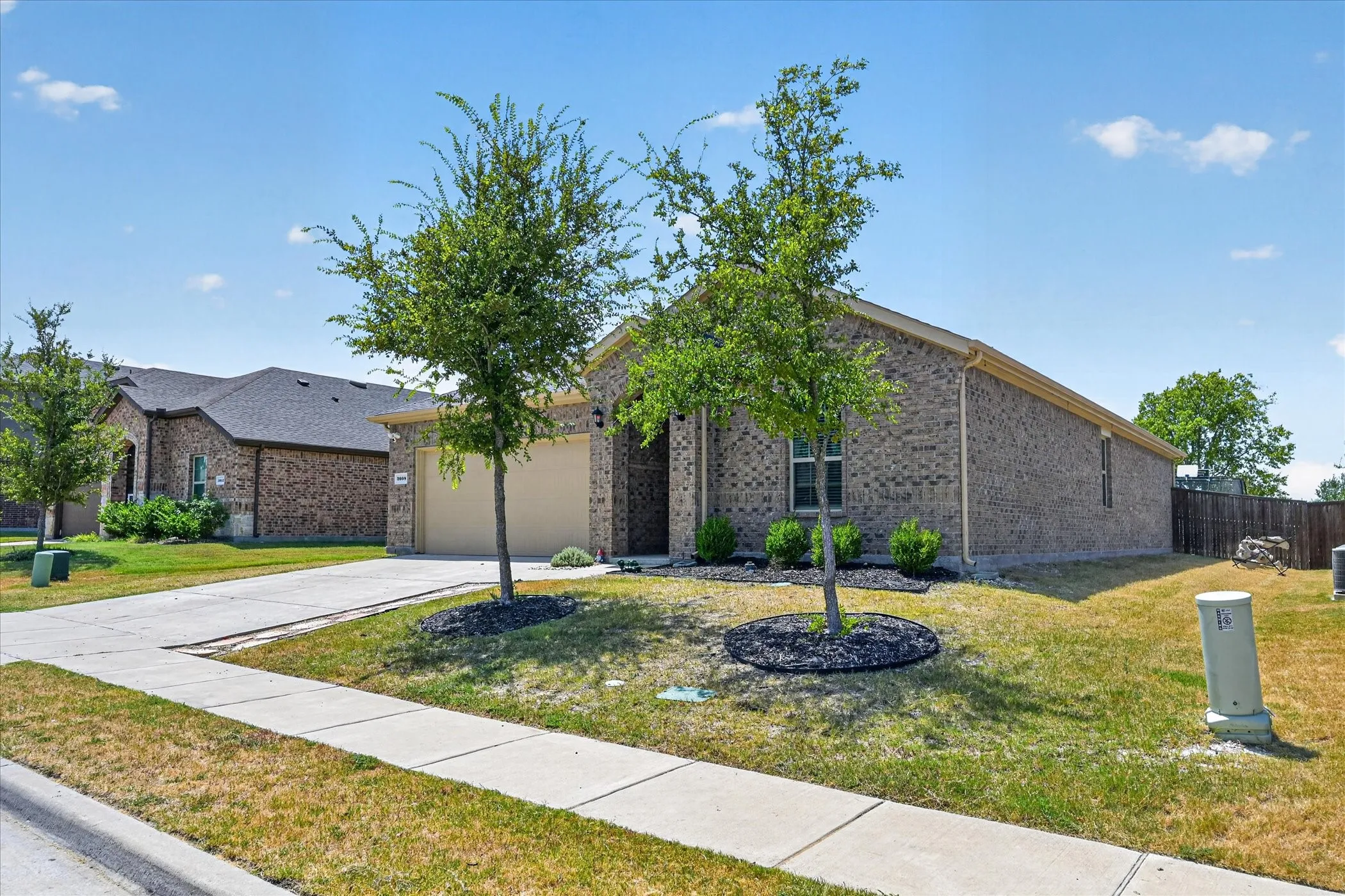 Brick facade with an attached garage and concrete driveway